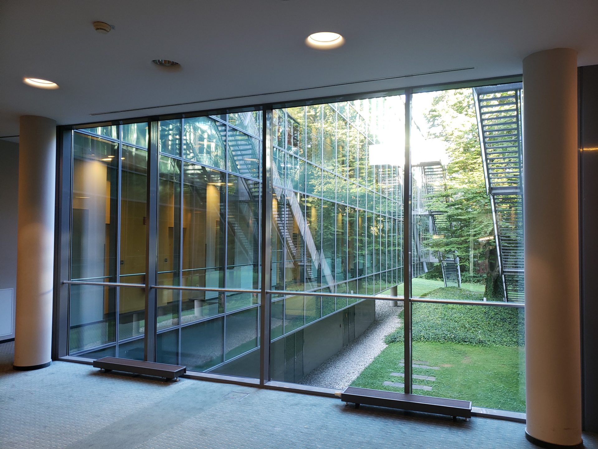 a glass wall with a staircase outside