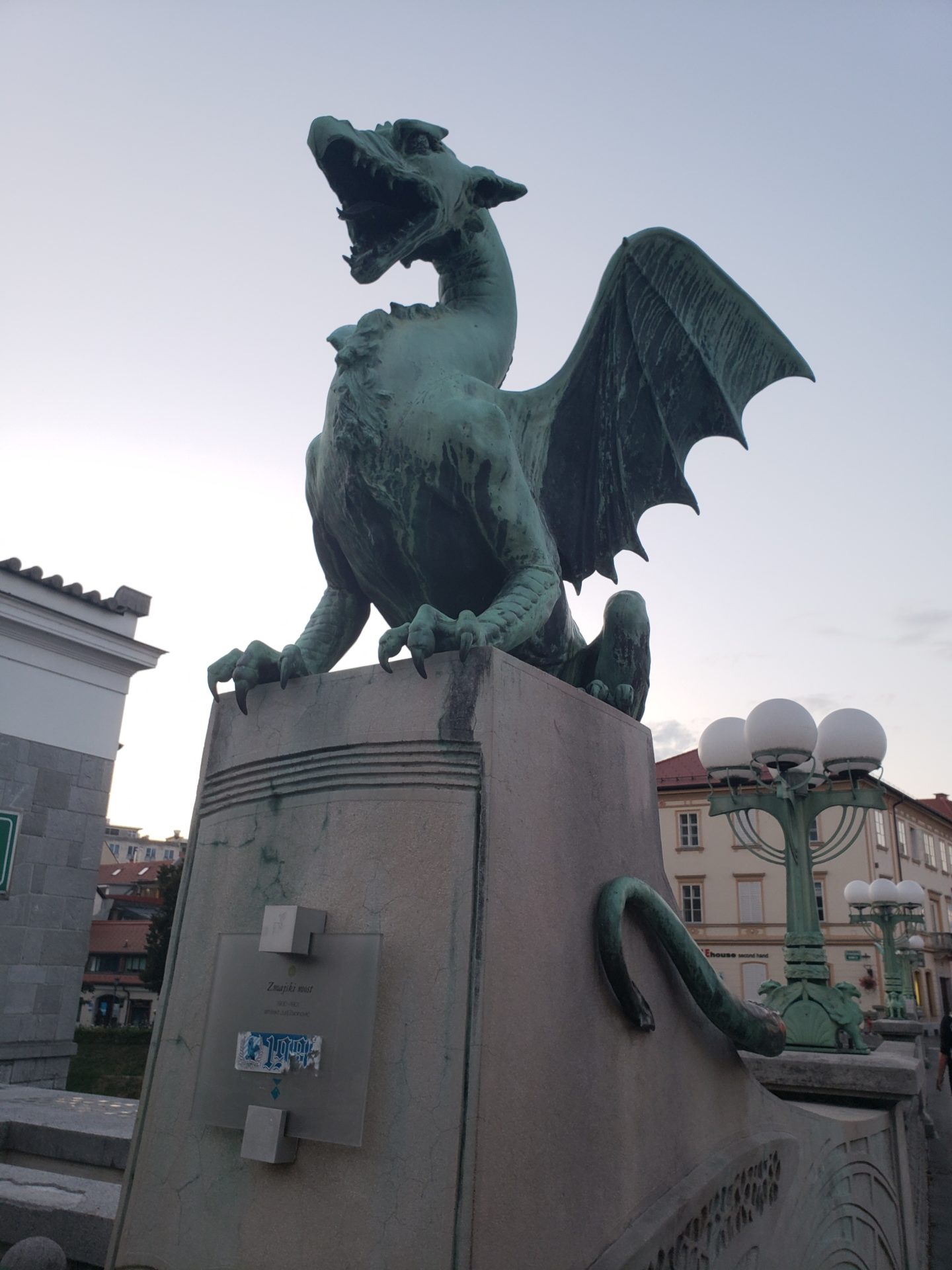 a green dragon statue on a concrete platform