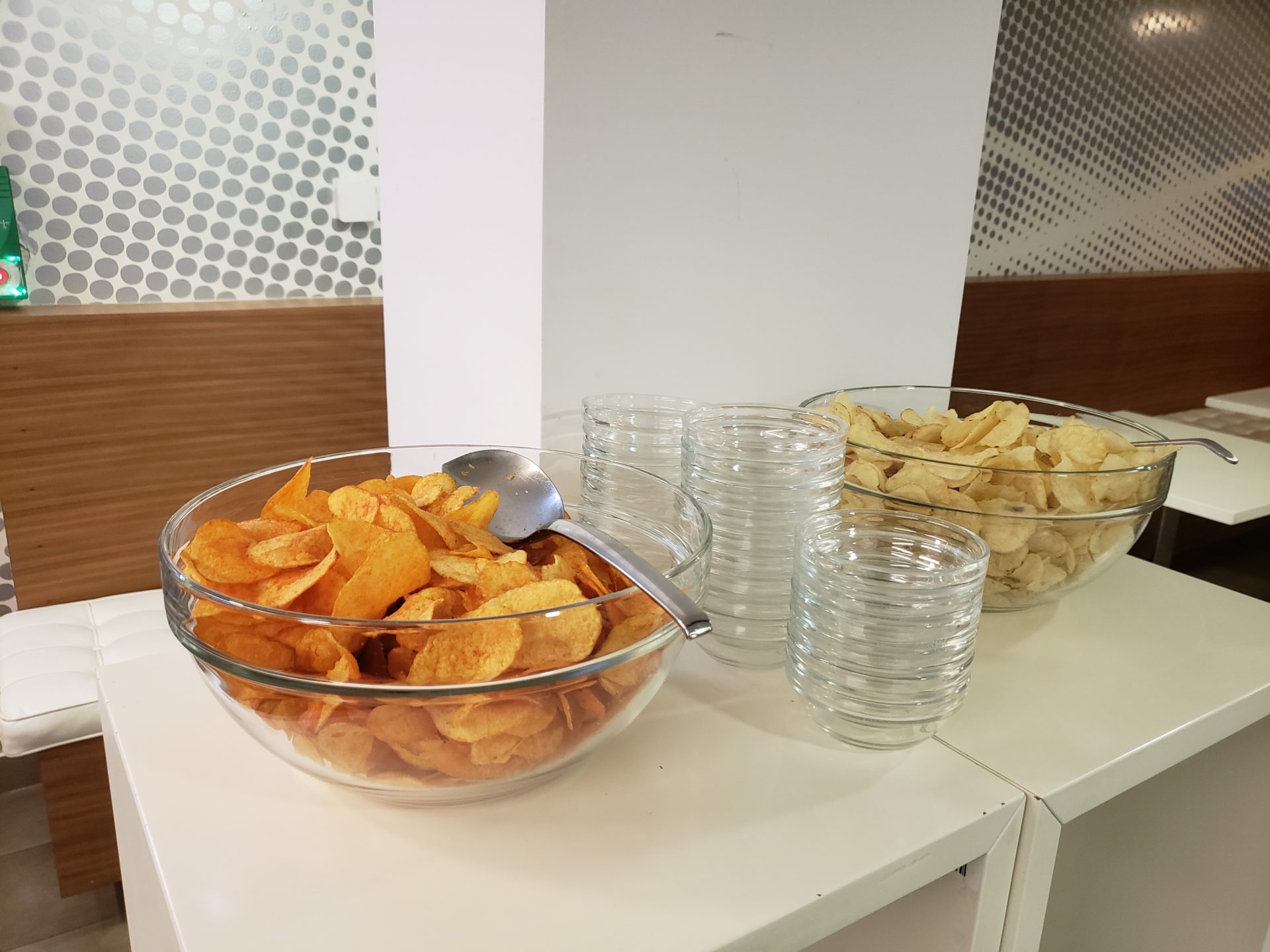 a group of bowls of potato chips and glasses