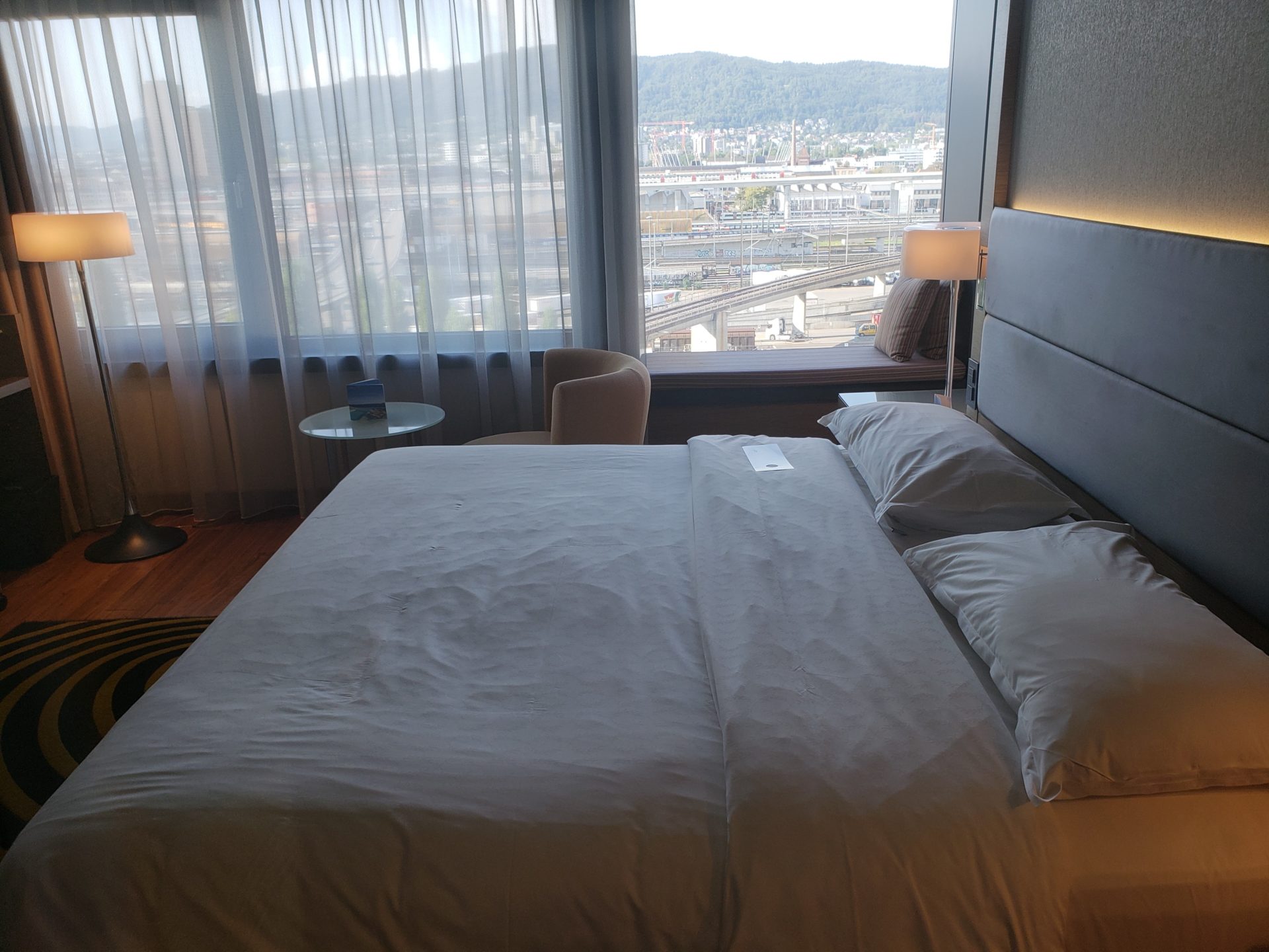 a bed with a window and a city view