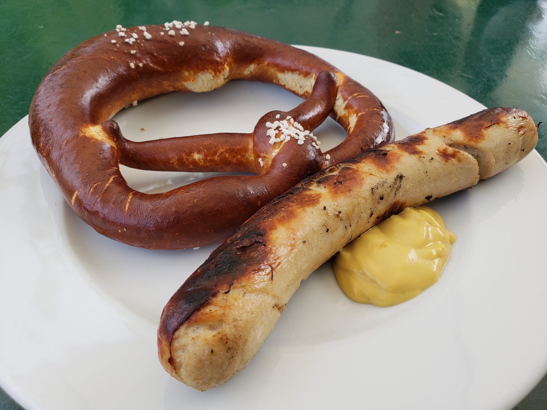 a sausage and pretzel on a plate