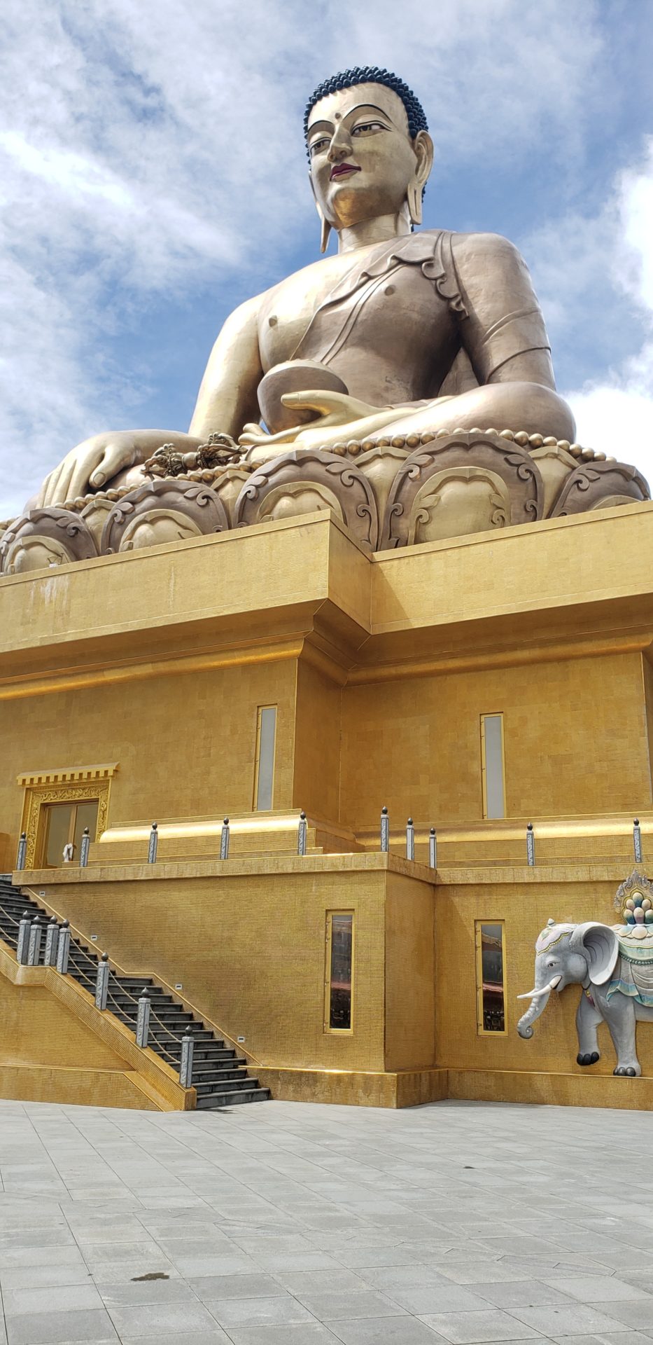a large gold statue of a buddha on a gold platform
