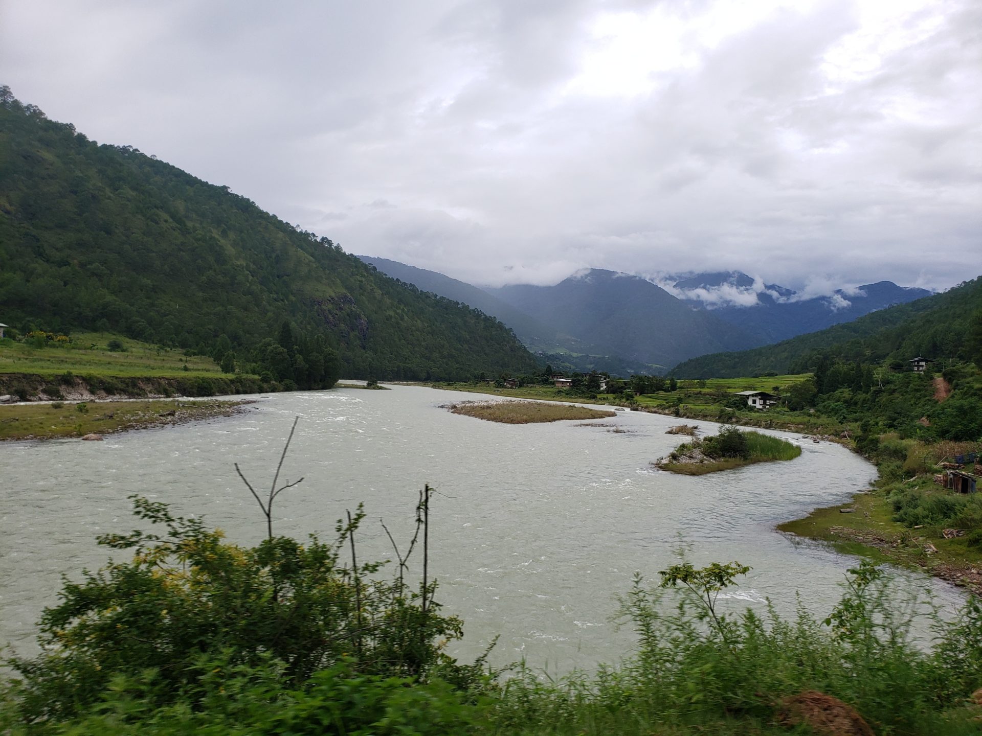 a river with a winding road and mountains in the background