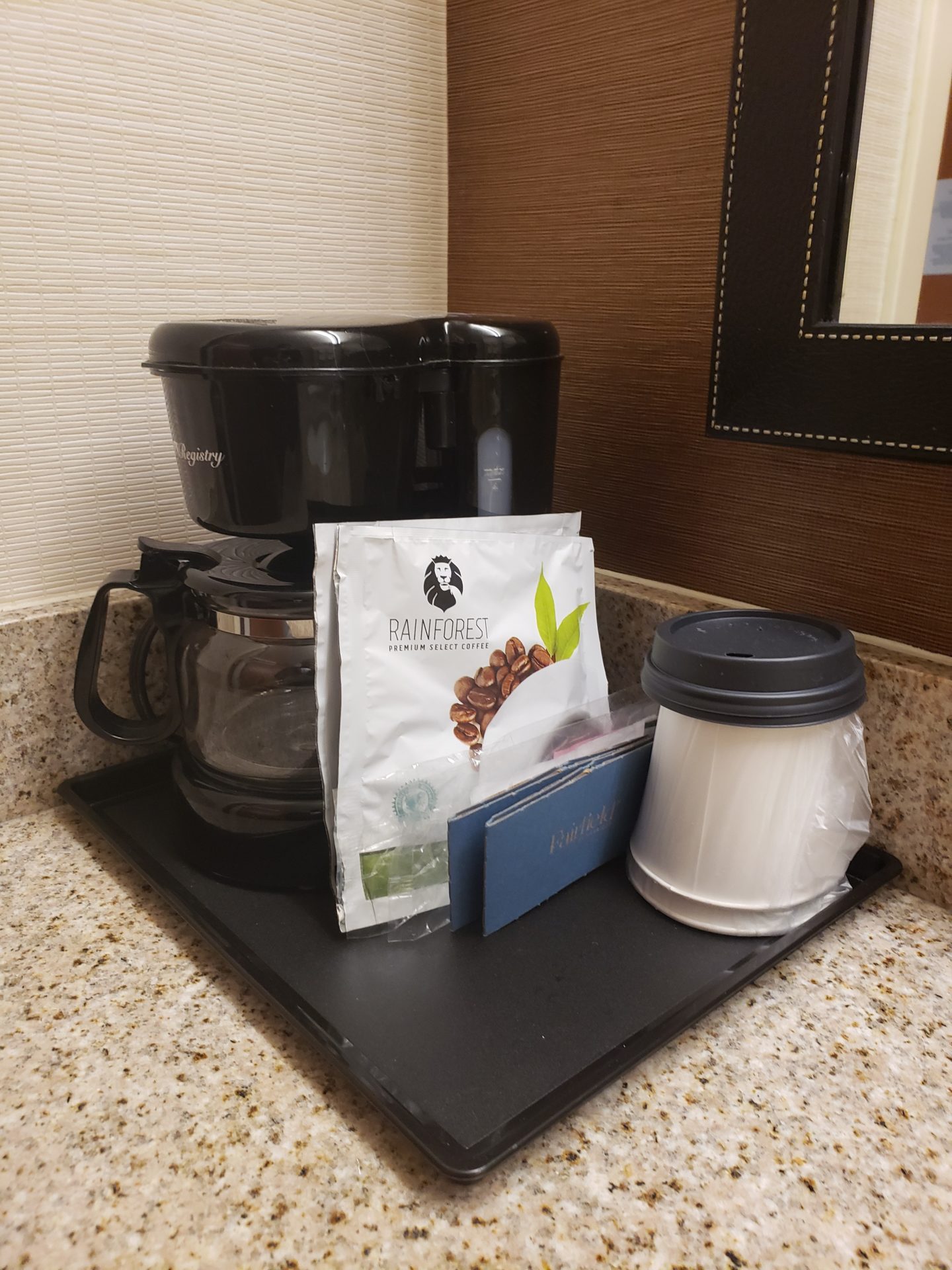 a coffee maker and coffee bag on a tray