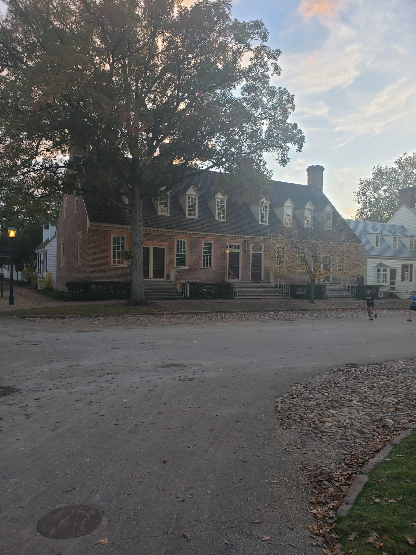 a brick building with a couple of people running in front of it