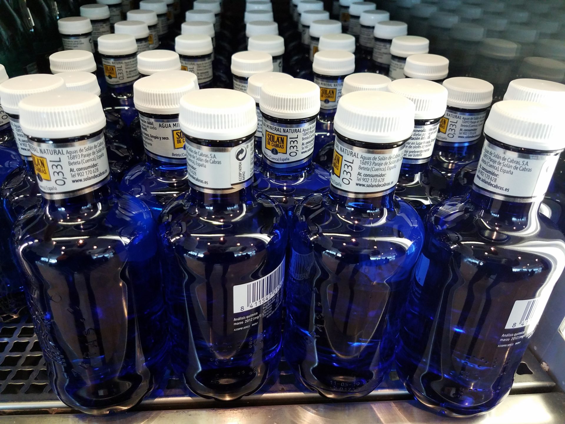 a group of blue bottles with white caps
