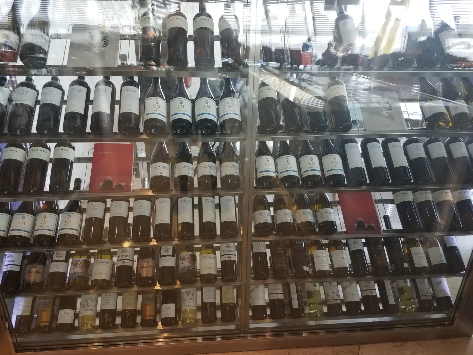 a glass shelf with bottles of wine
