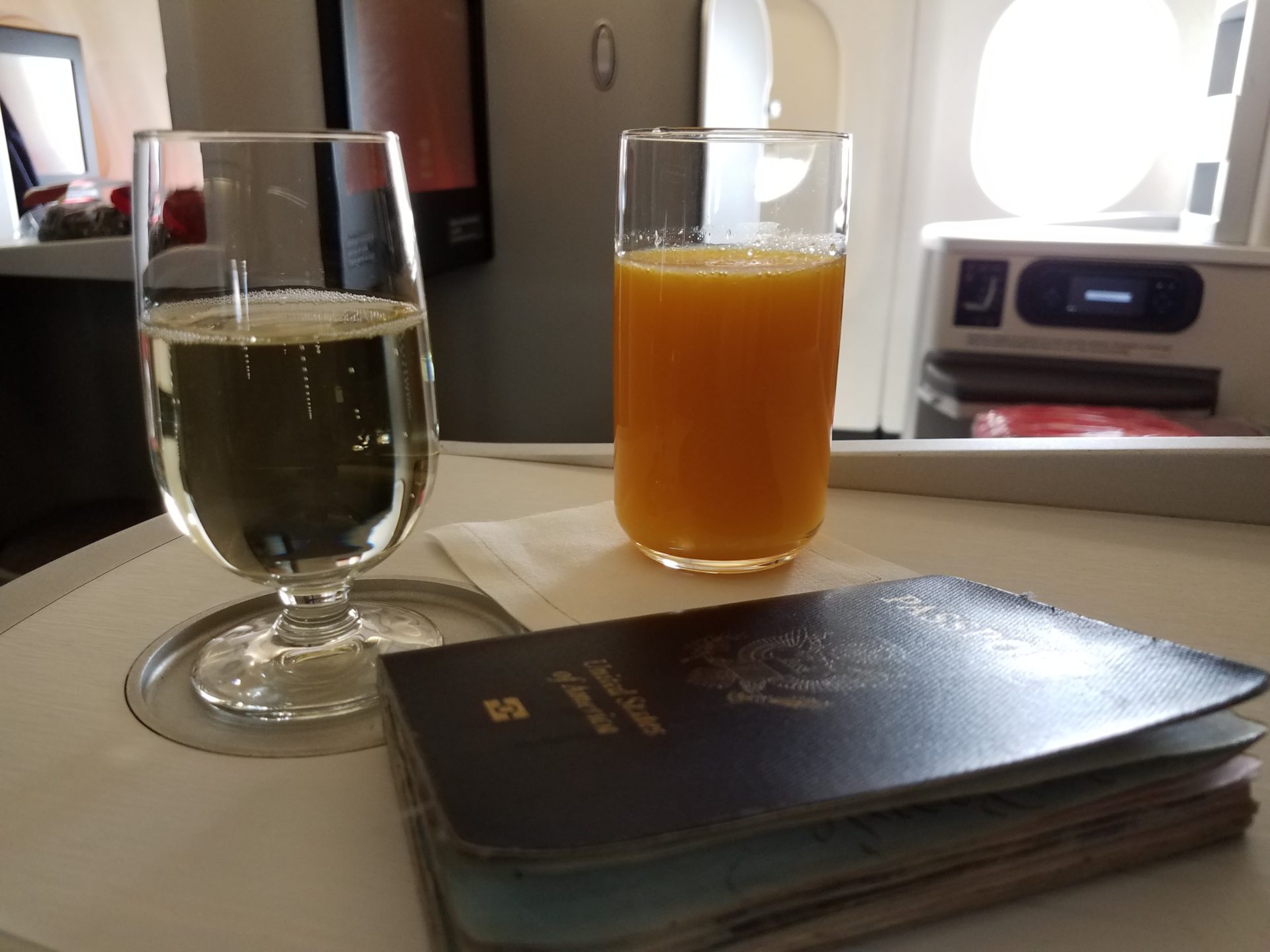 a glass of orange juice and a passport on a table