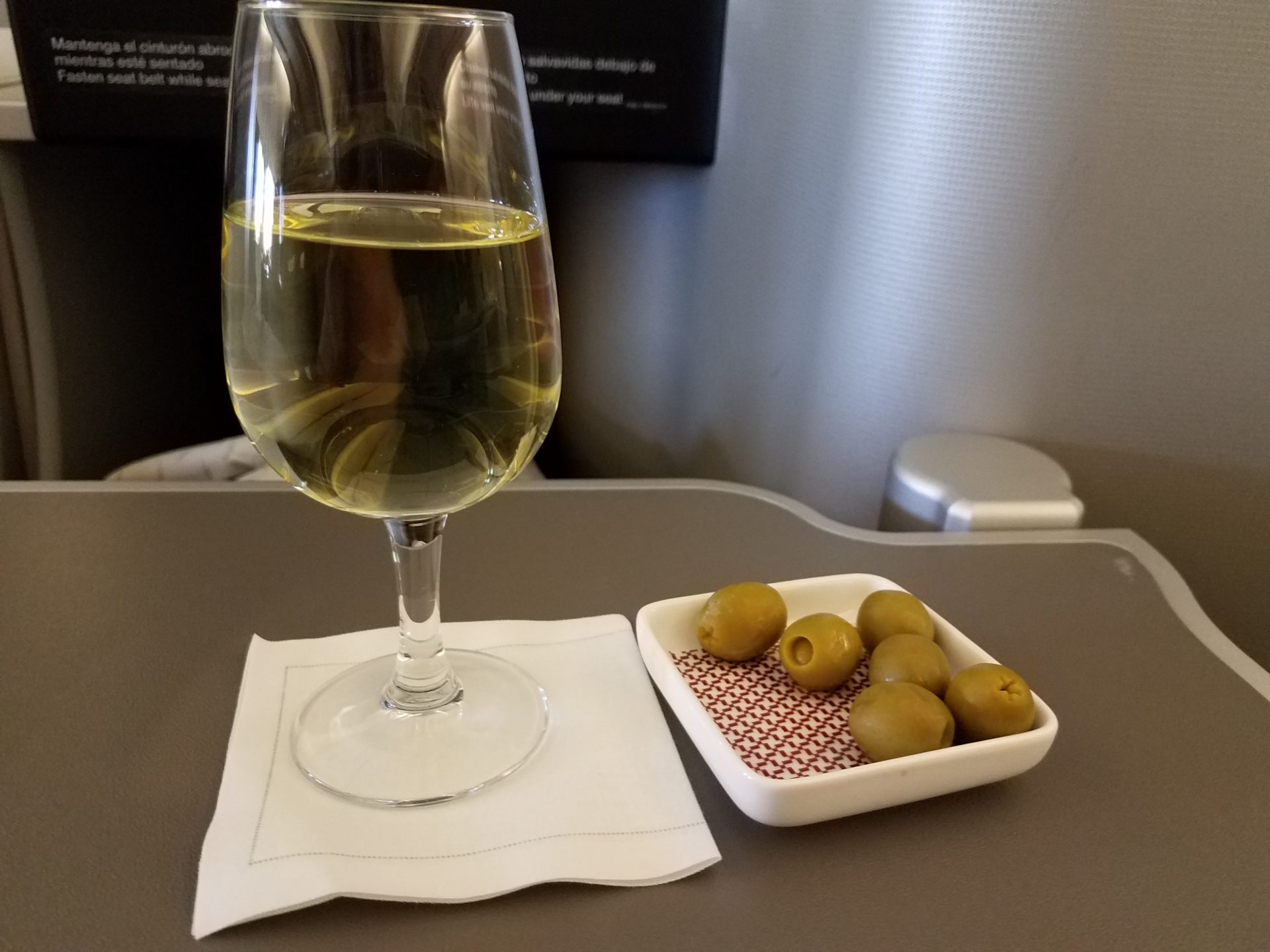 a glass of wine and olives on a table