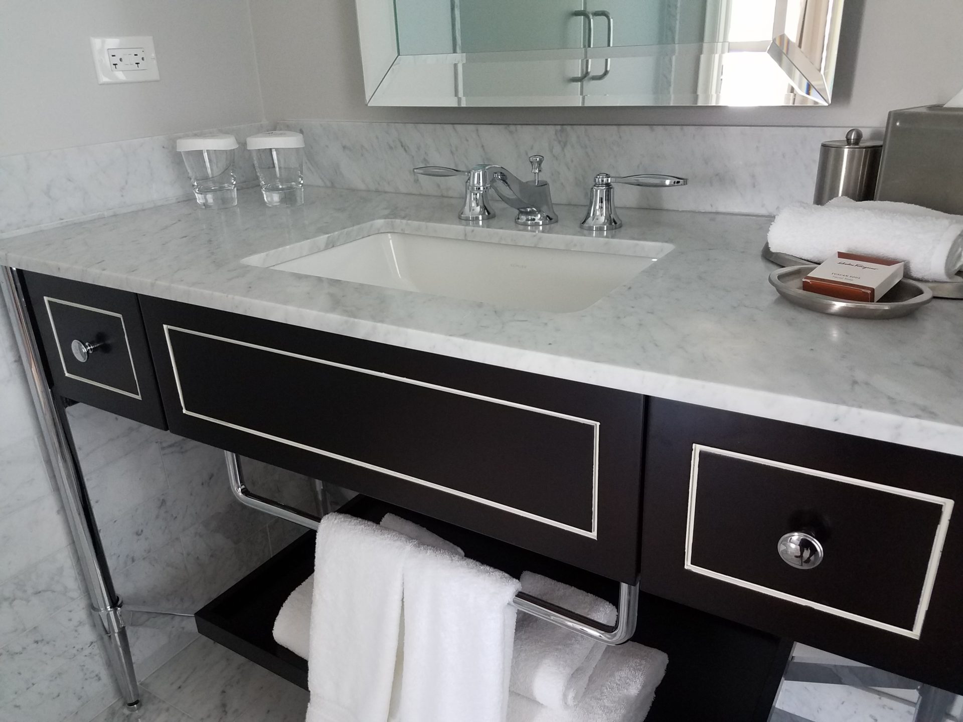 a bathroom sink with a mirror and towels