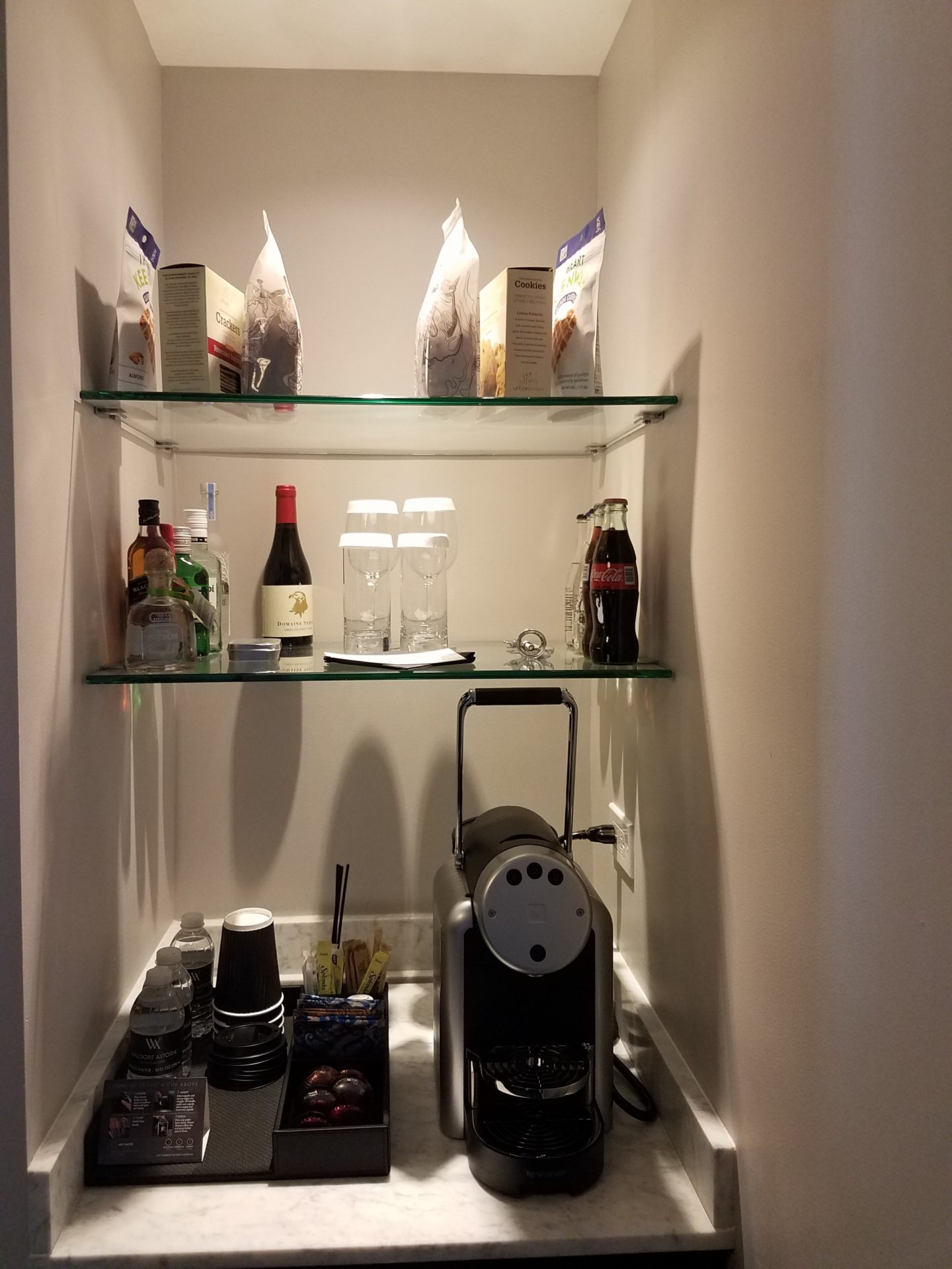 a shelf with glass shelves and coffee machine