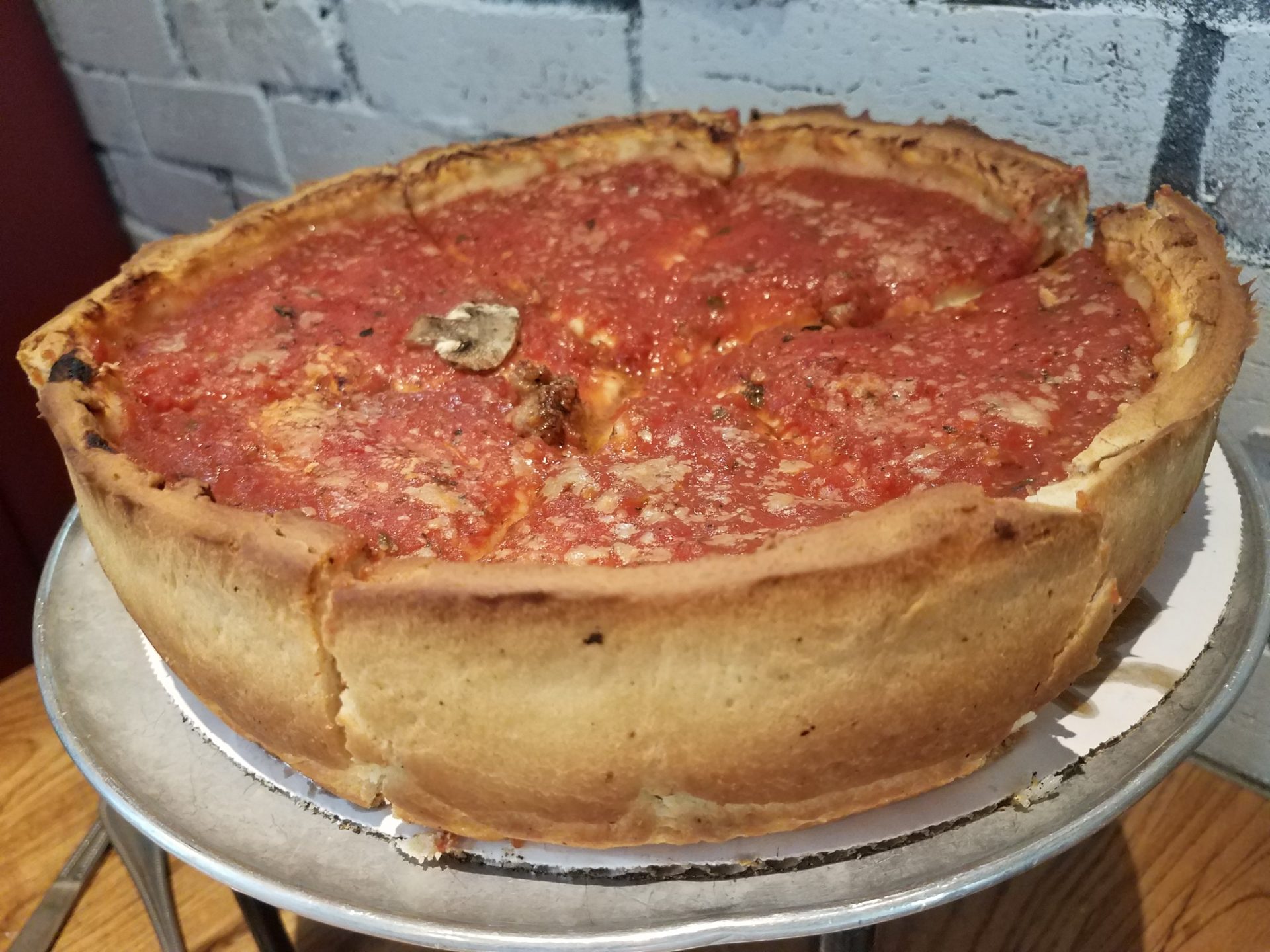 a deep dish pizza on a metal tray