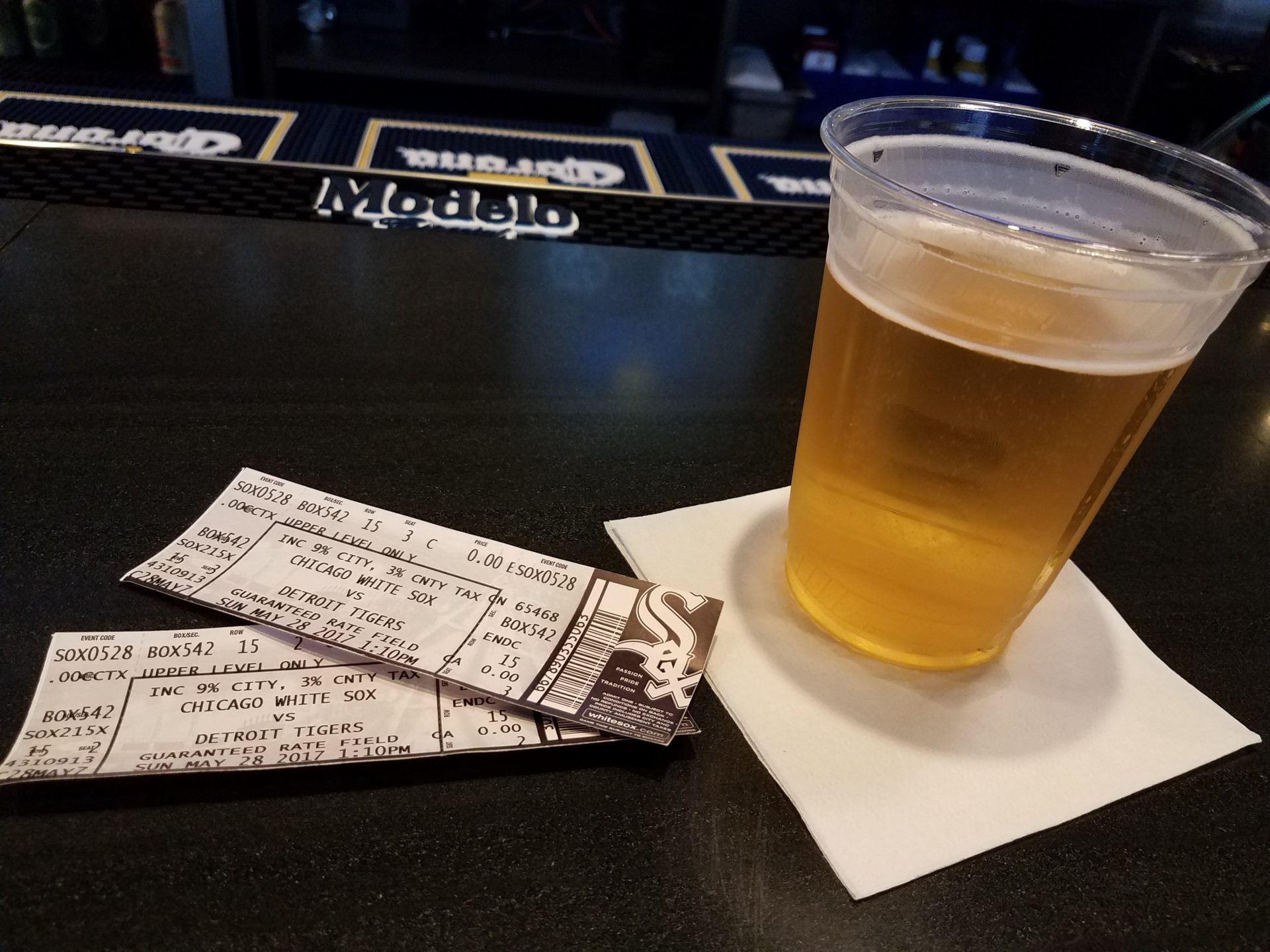 a glass of beer and tickets on a table