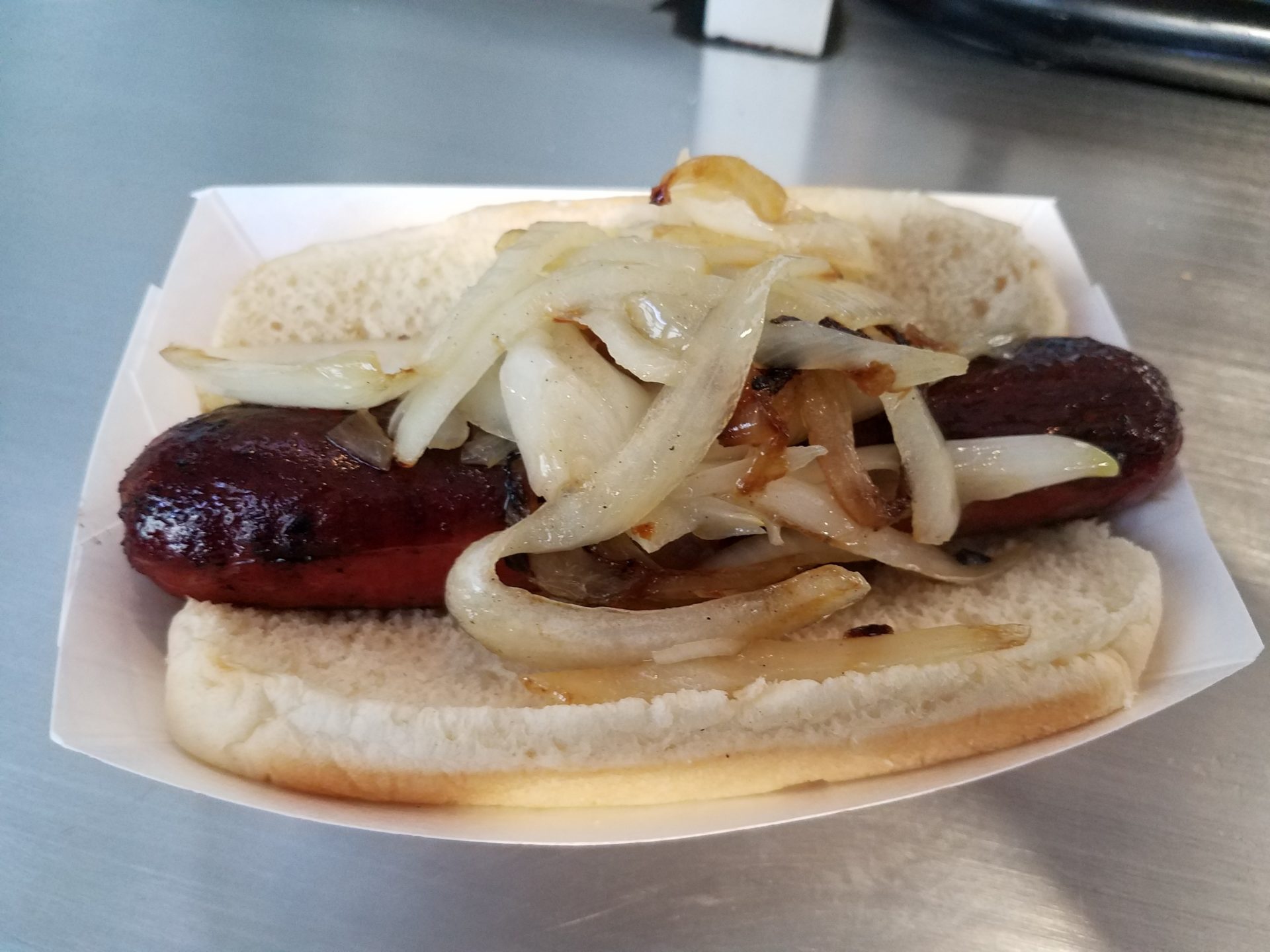 a hot dog with onions on a bun
