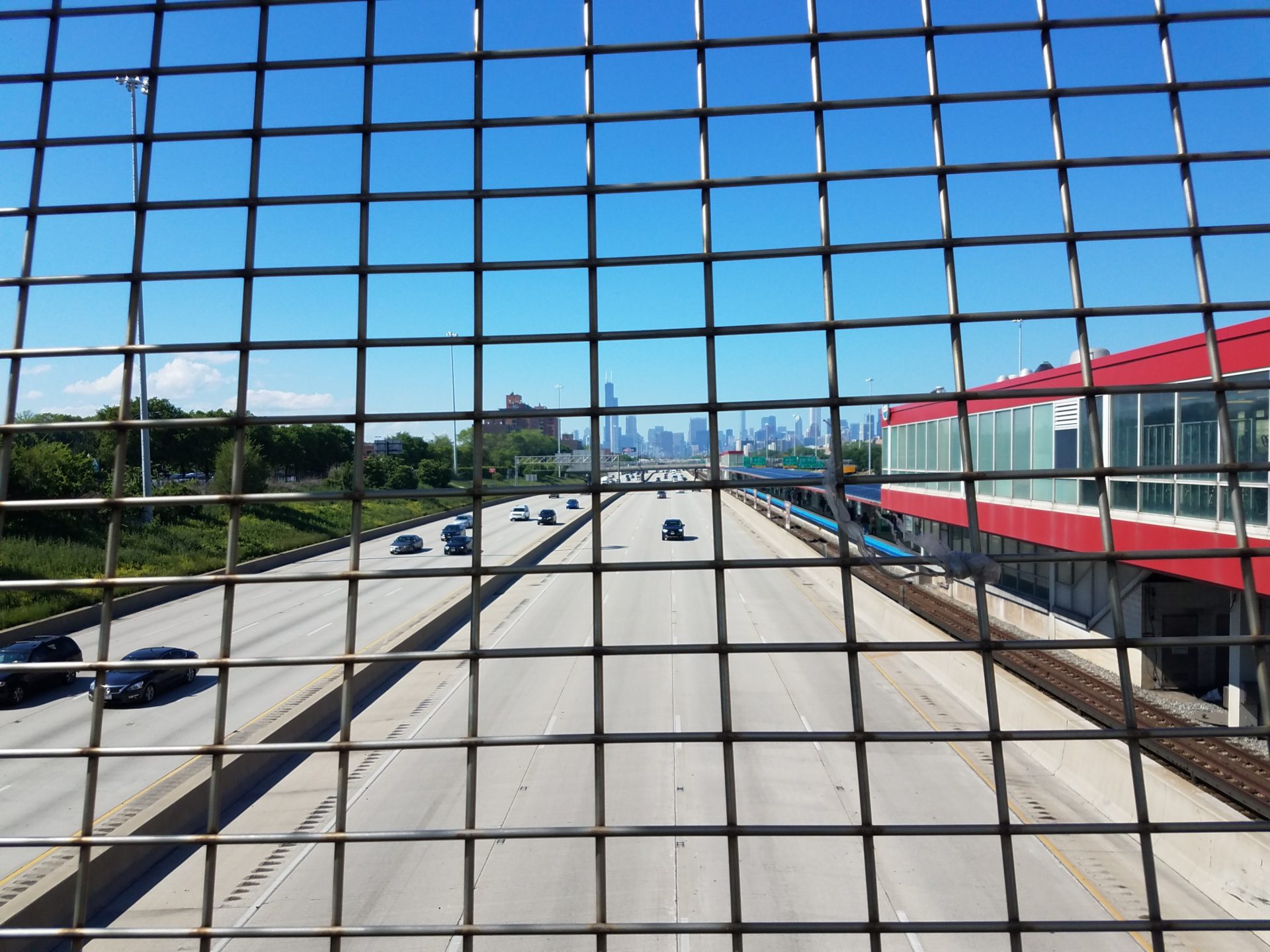 a view of a highway through a fence