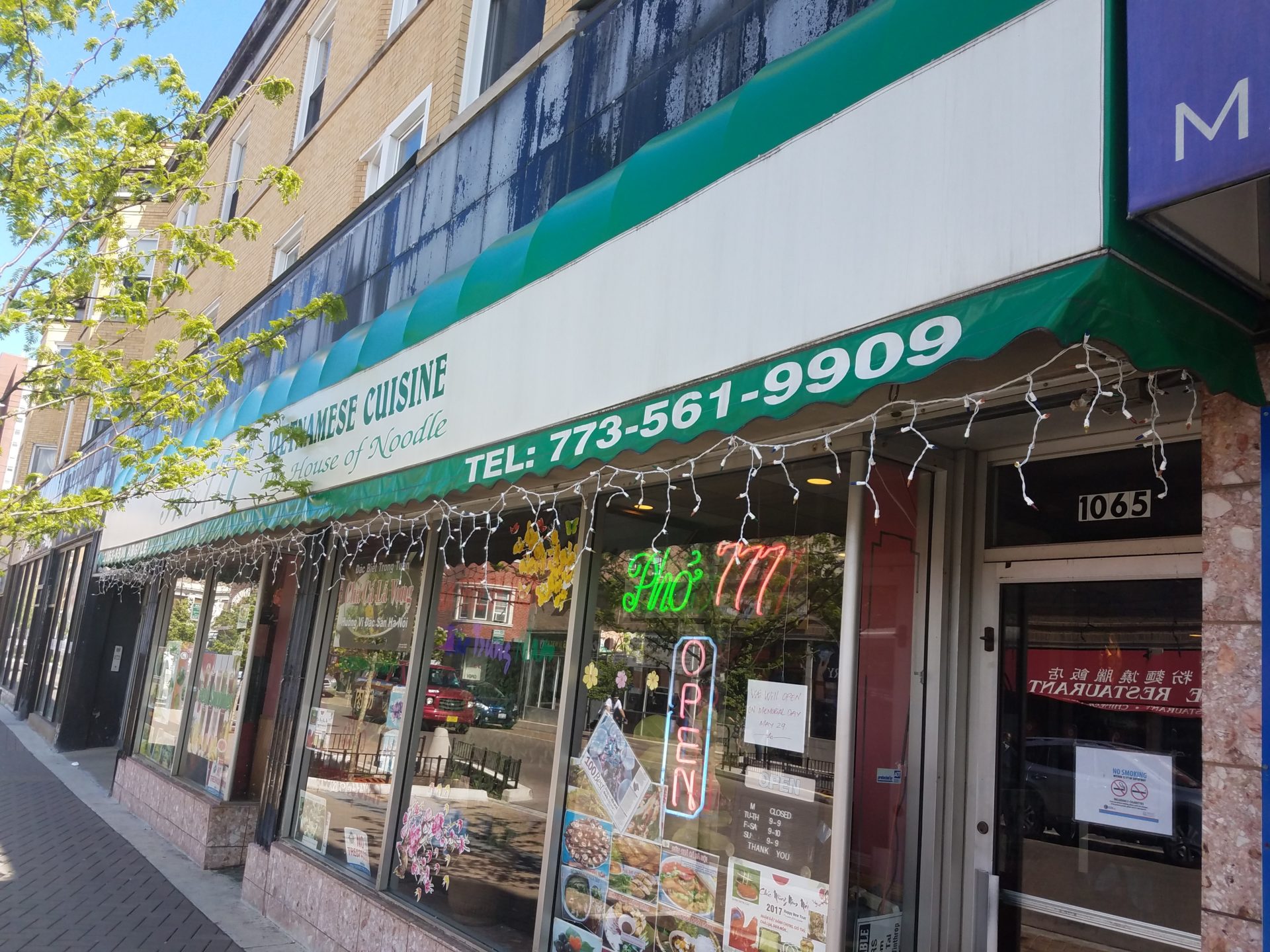 a store front with a green awning and white letters