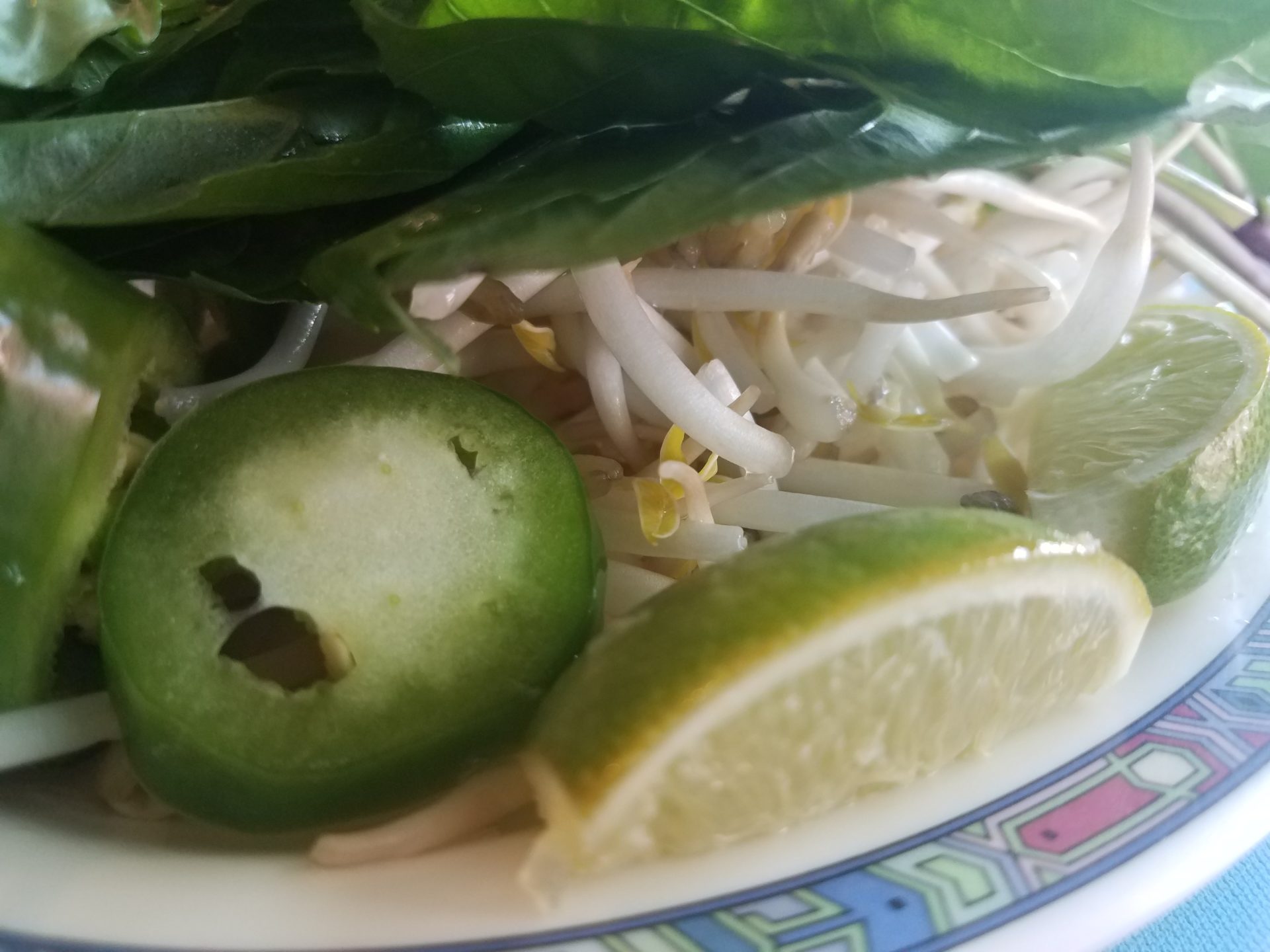 a plate of food with vegetables and limes