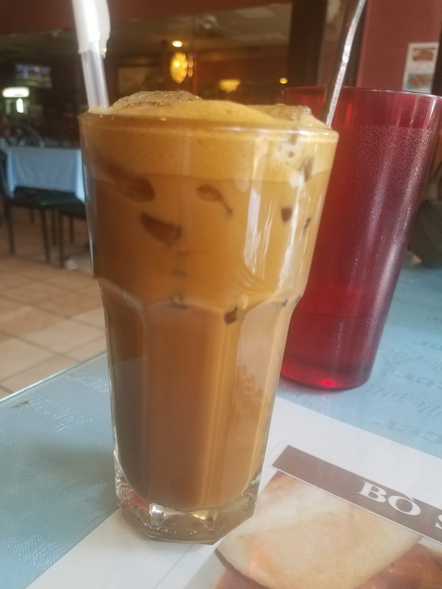 a glass of coffee with a straw