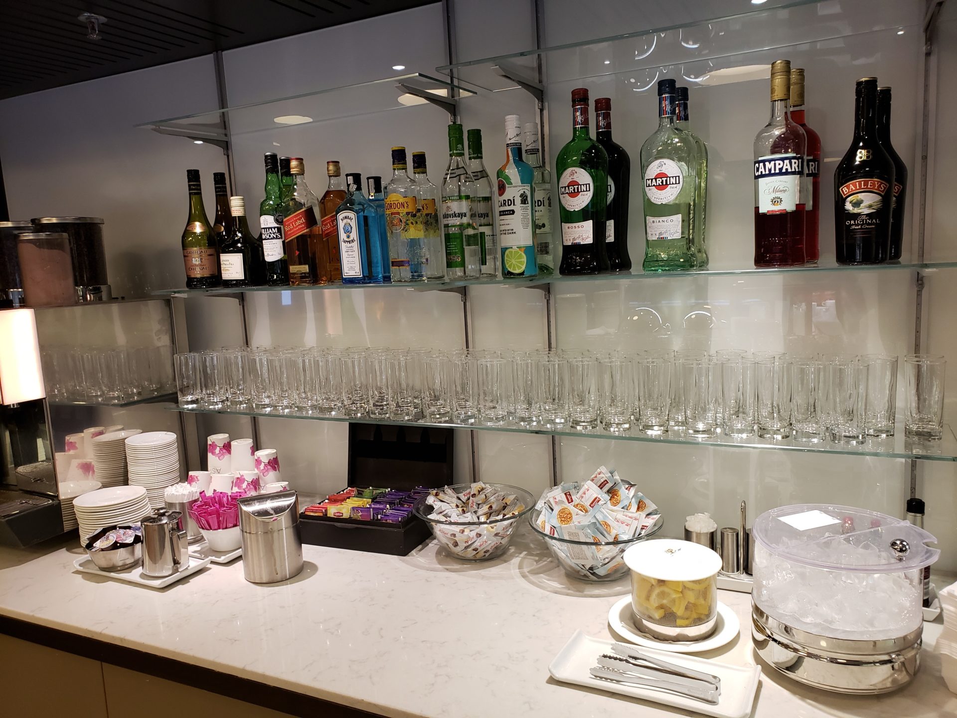 a bar with many bottles of alcohol and glasses