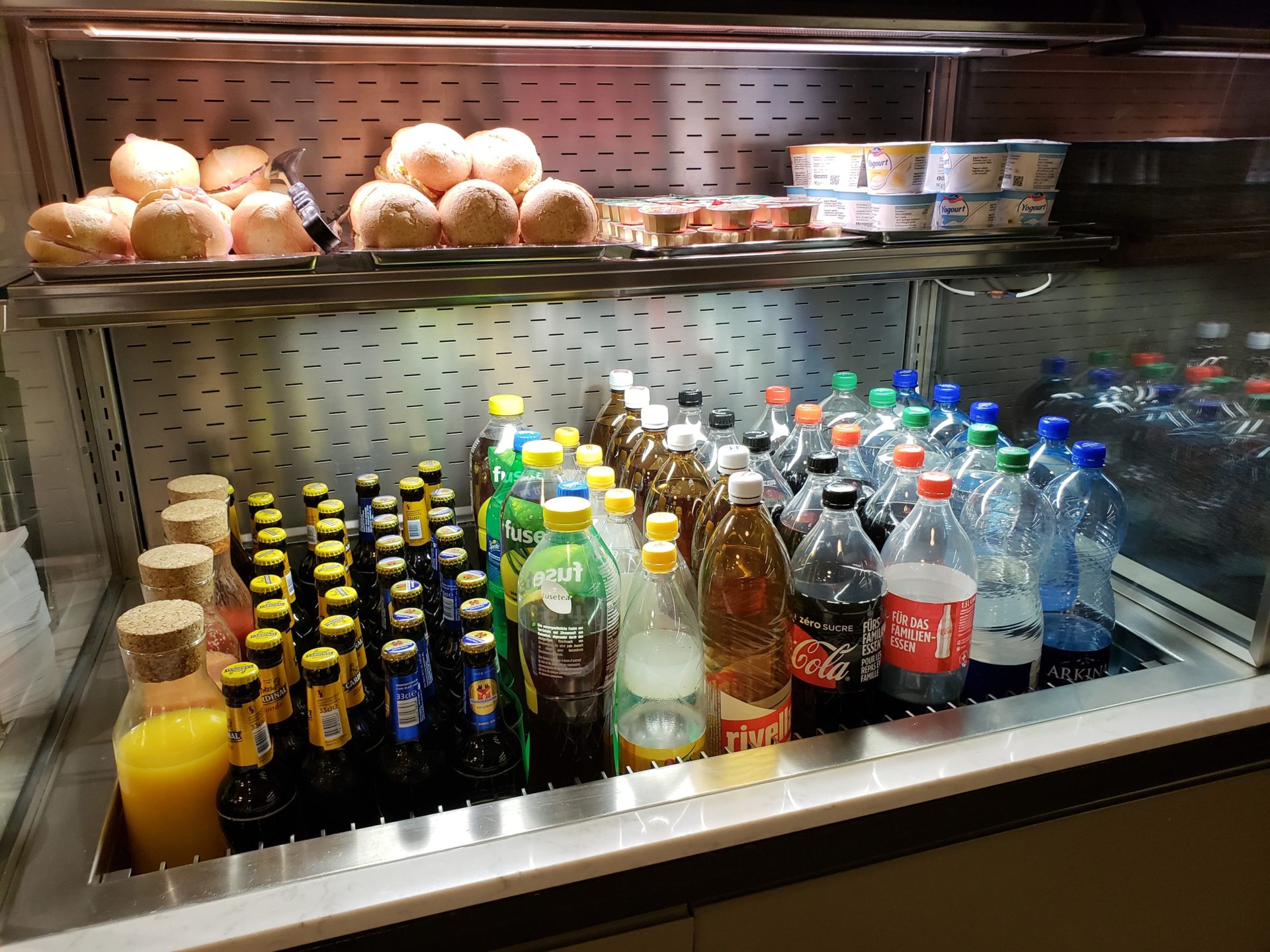 a display case with bottles of soda and other beverages