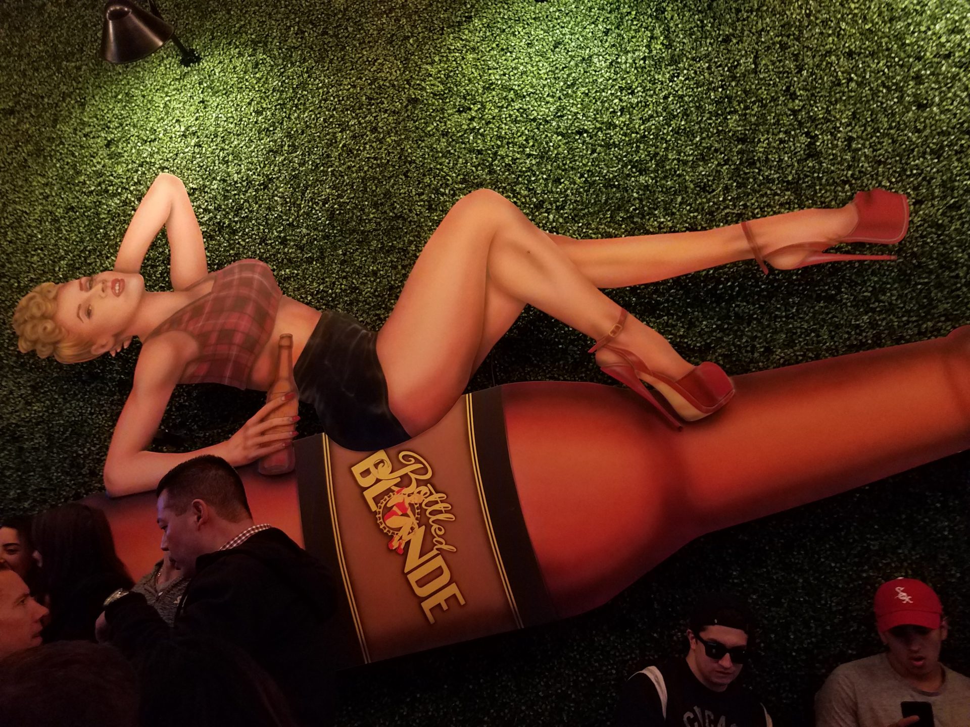 a poster of a woman lying on a beer bottle