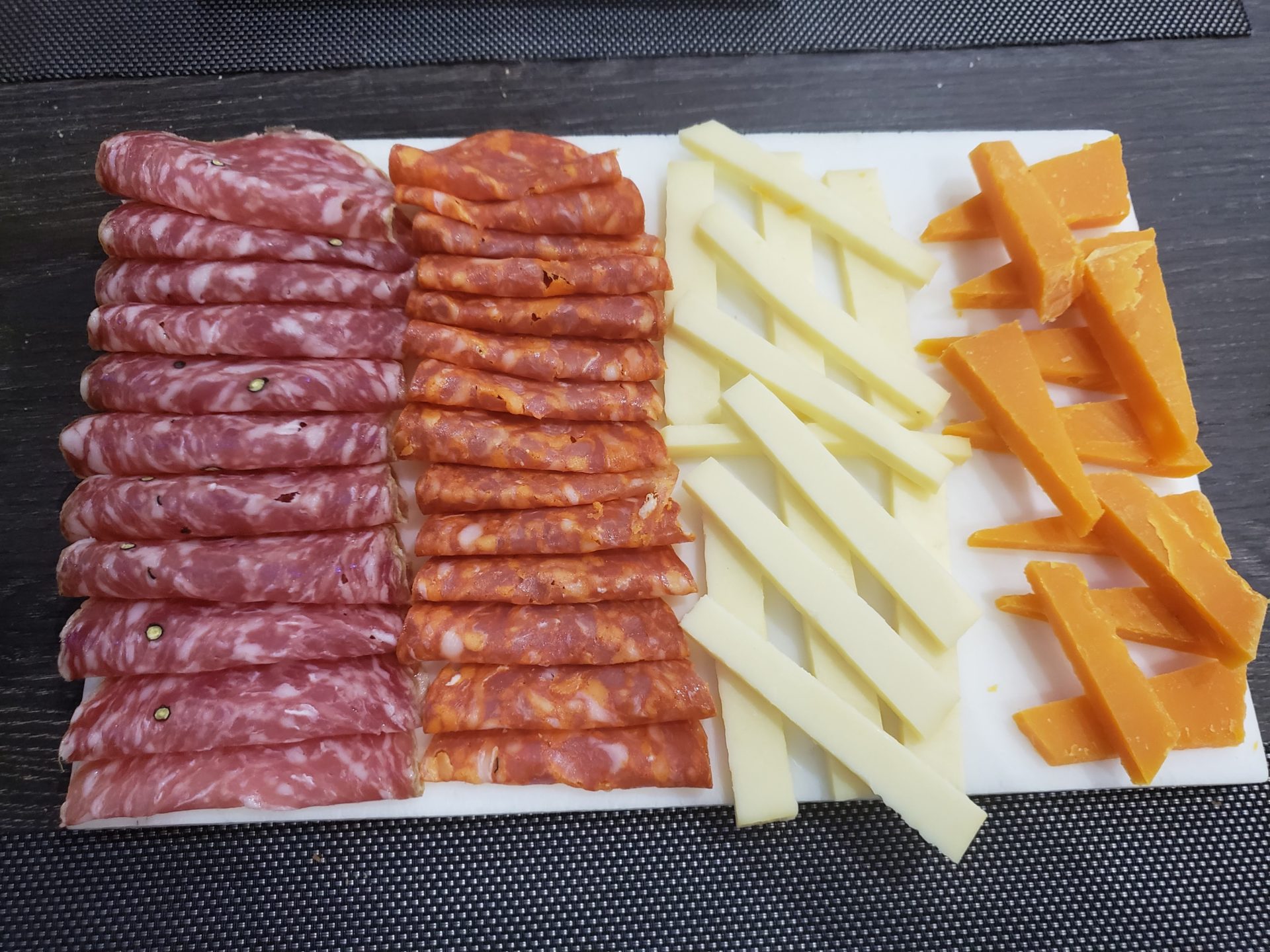 a cheese and meat on a cutting board