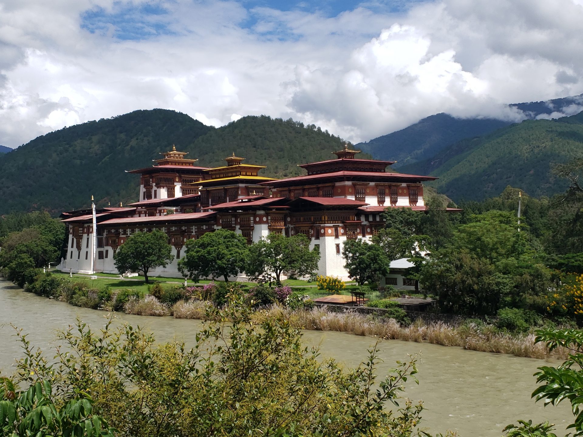 Punakha Dzong with trees and mountains in the background