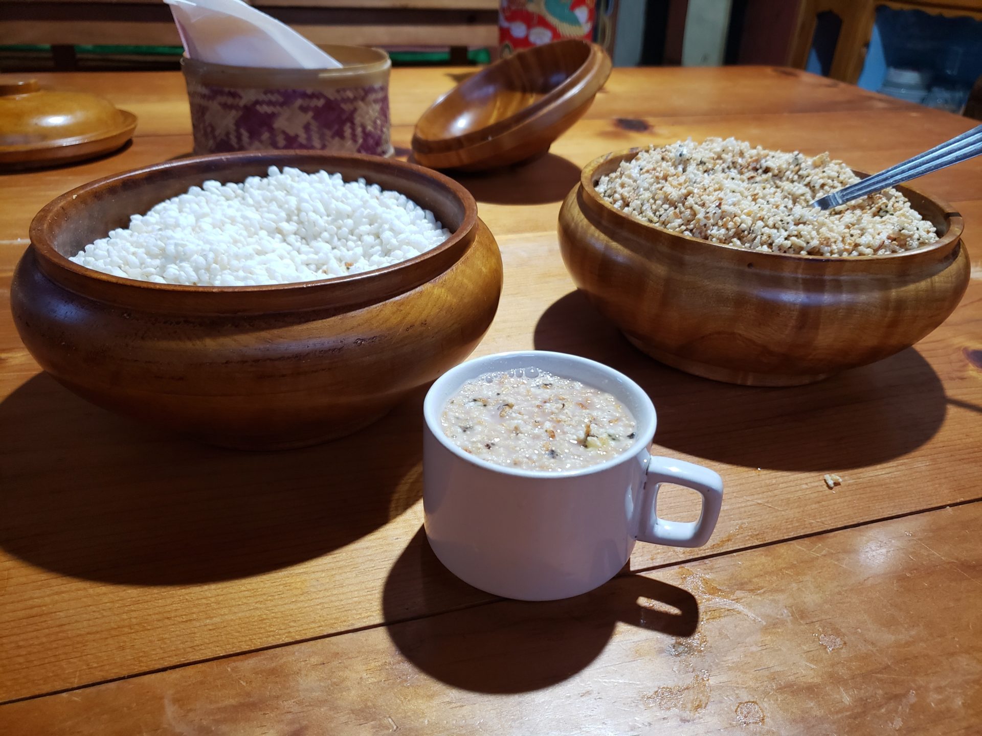 a bowl of rice and a mug of soup on a table