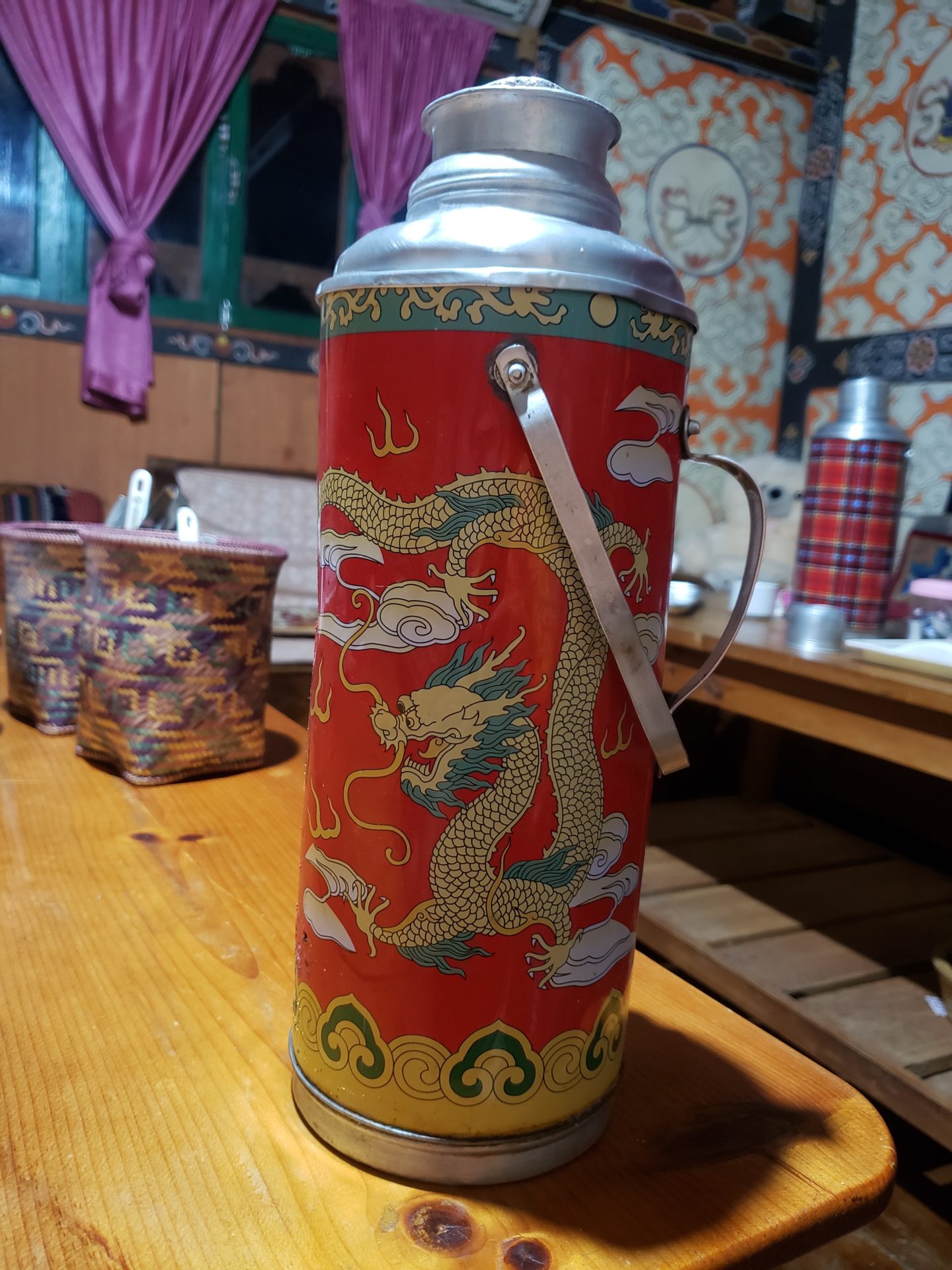 a red and silver thermos on a table