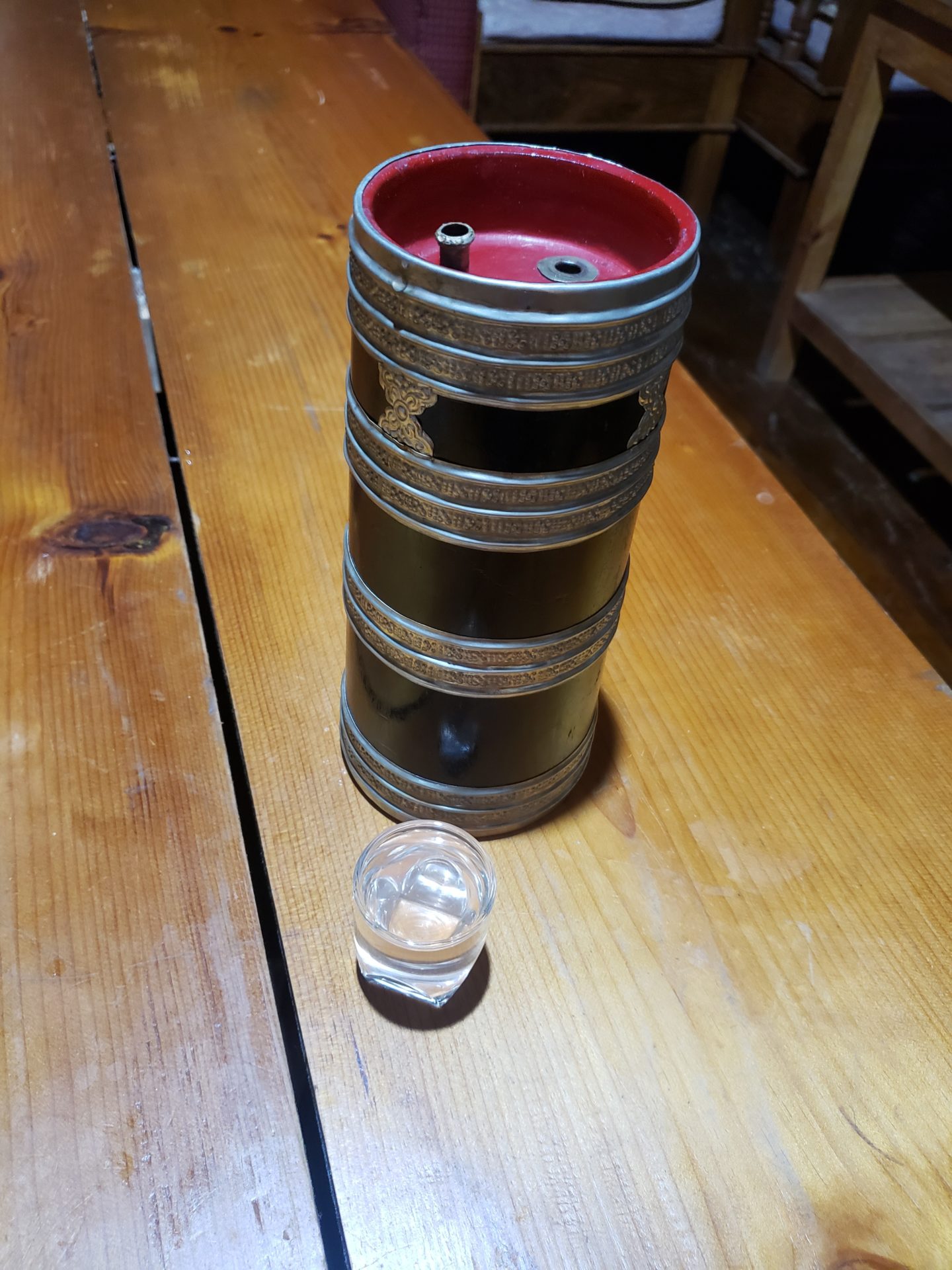 a metal barrel with a glass container on a table