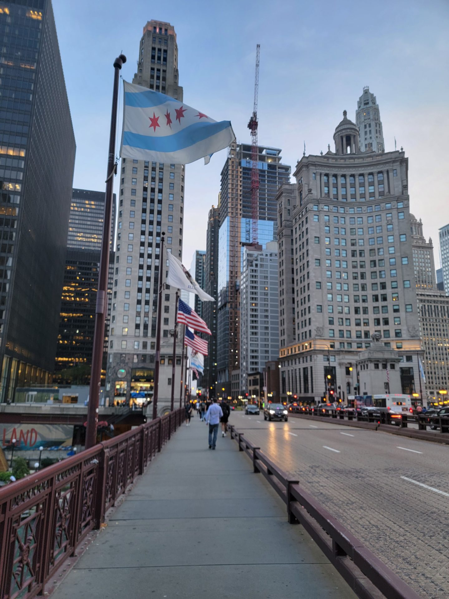 a bridge with flags on it and a city street with tall buildings