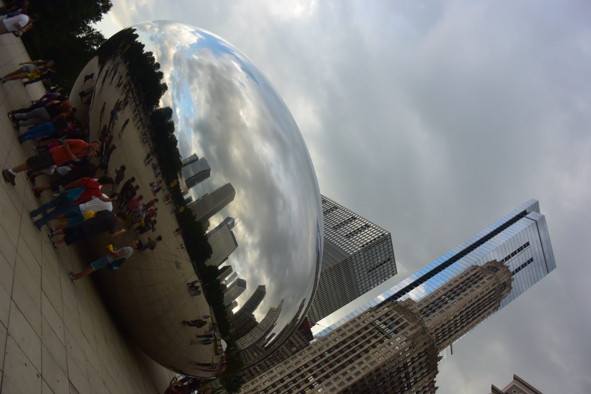 a large reflective ball with people in the background