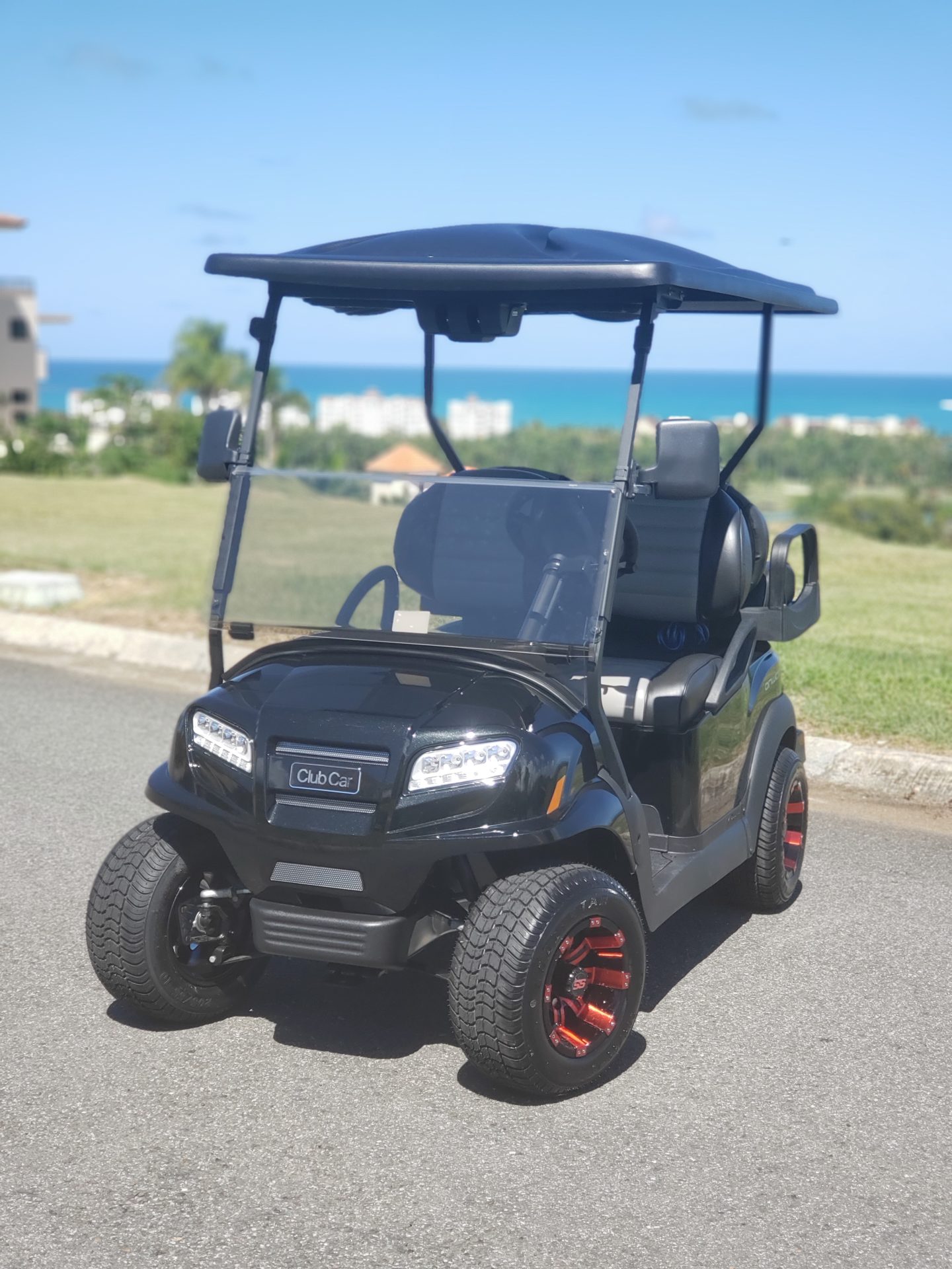 a black golf cart parked on a road