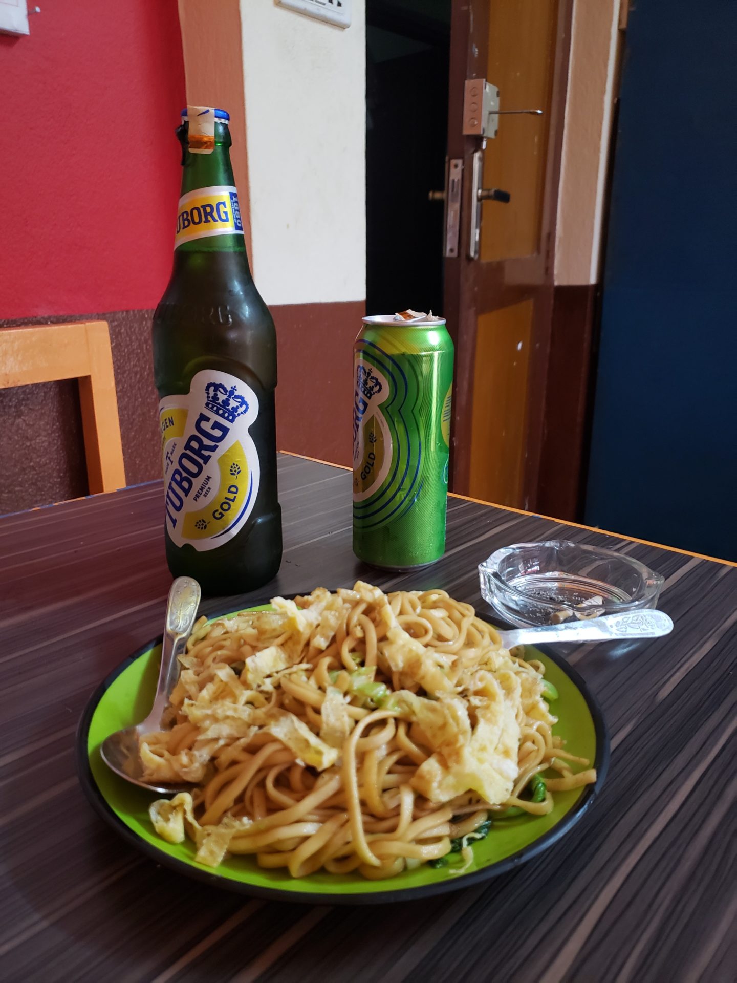a plate of food and two beer bottles on a table