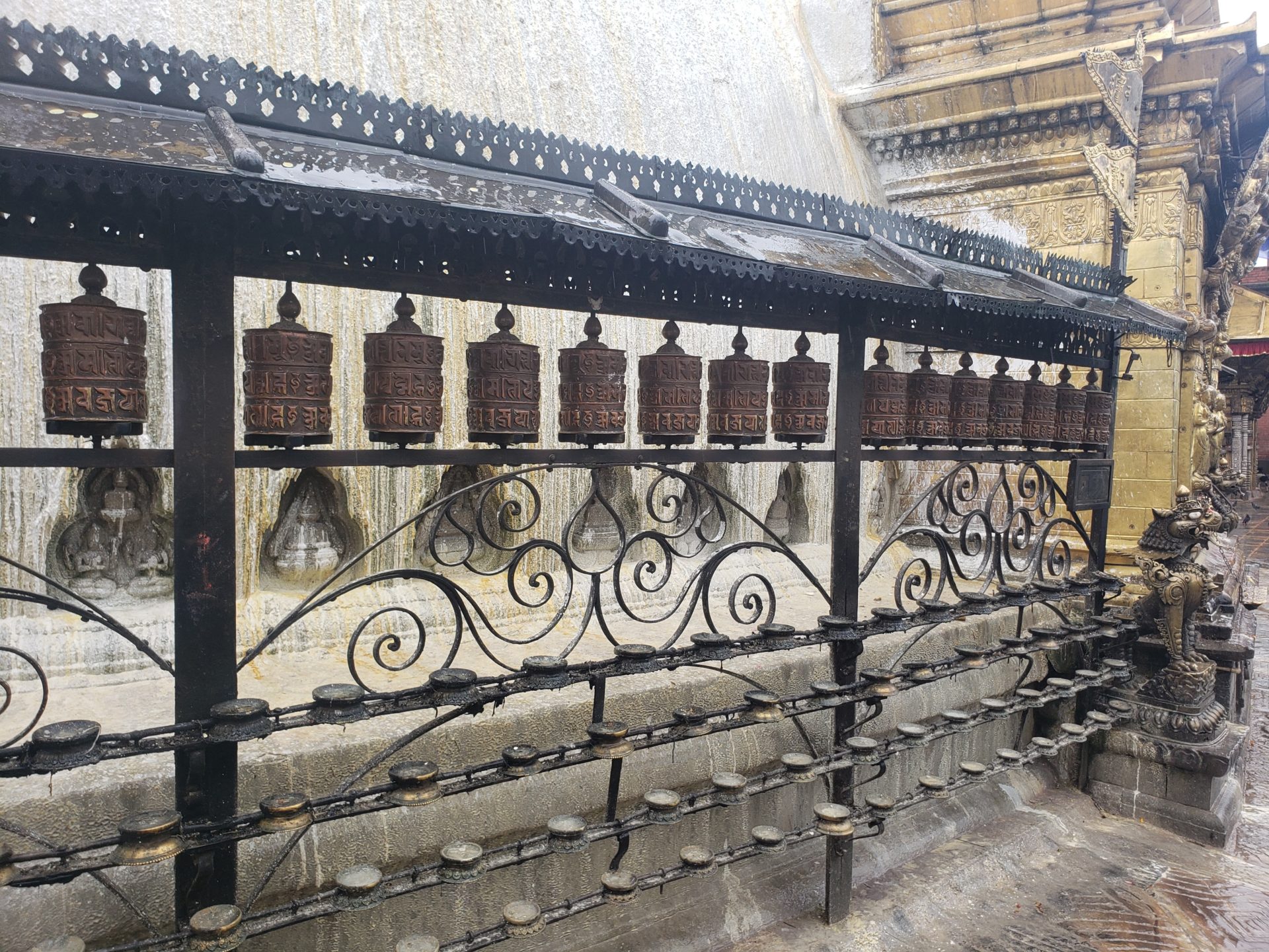 a metal fence with prayer wheels