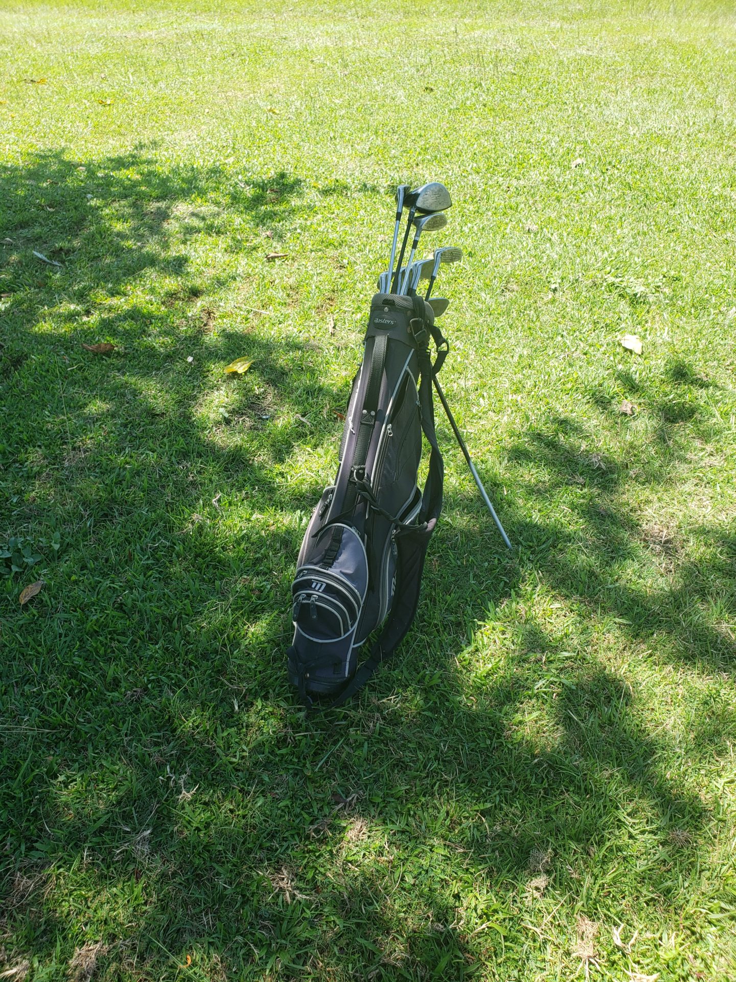 a golf bag with clubs on grass