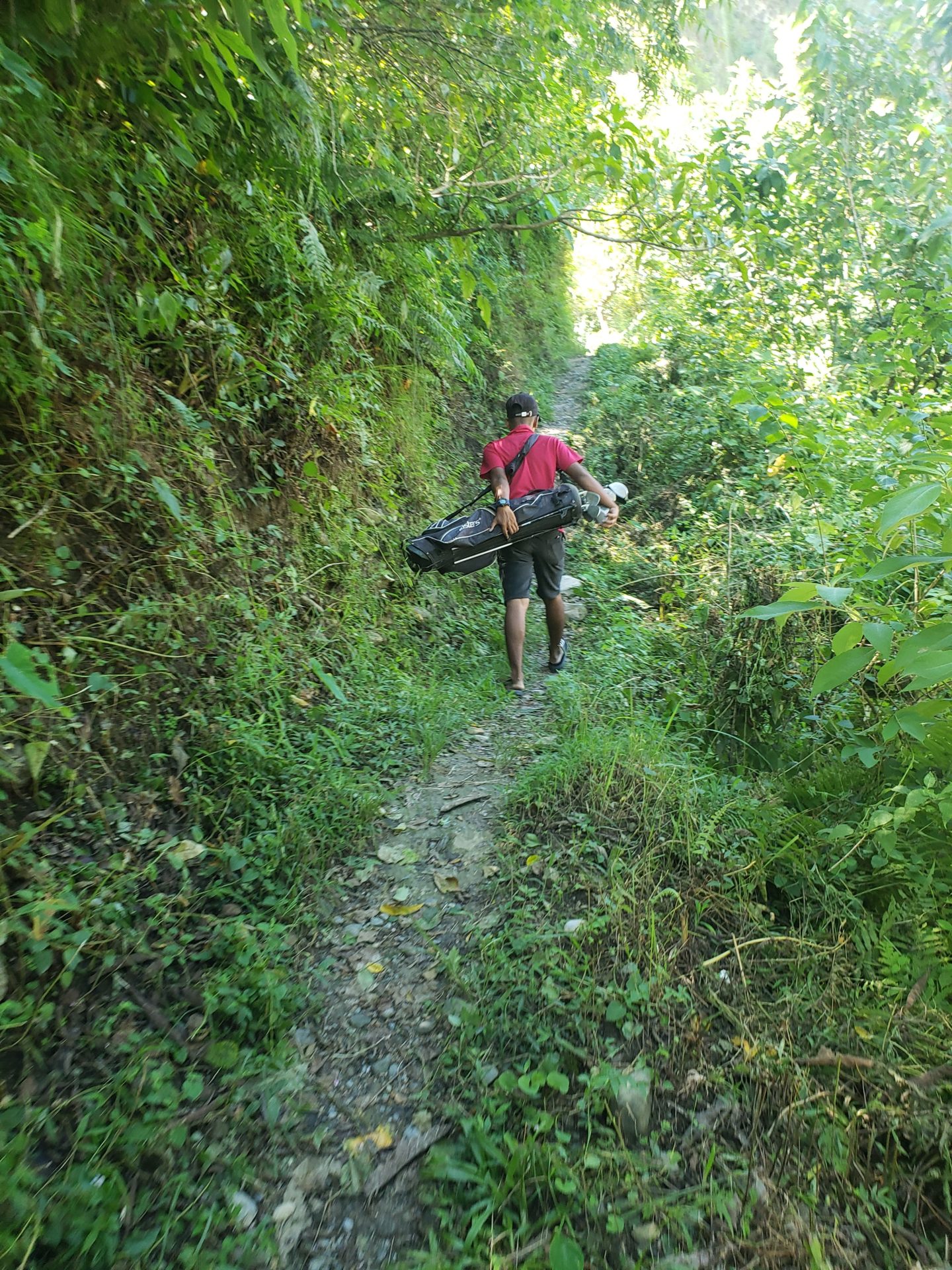 a man carrying a bag on a trail