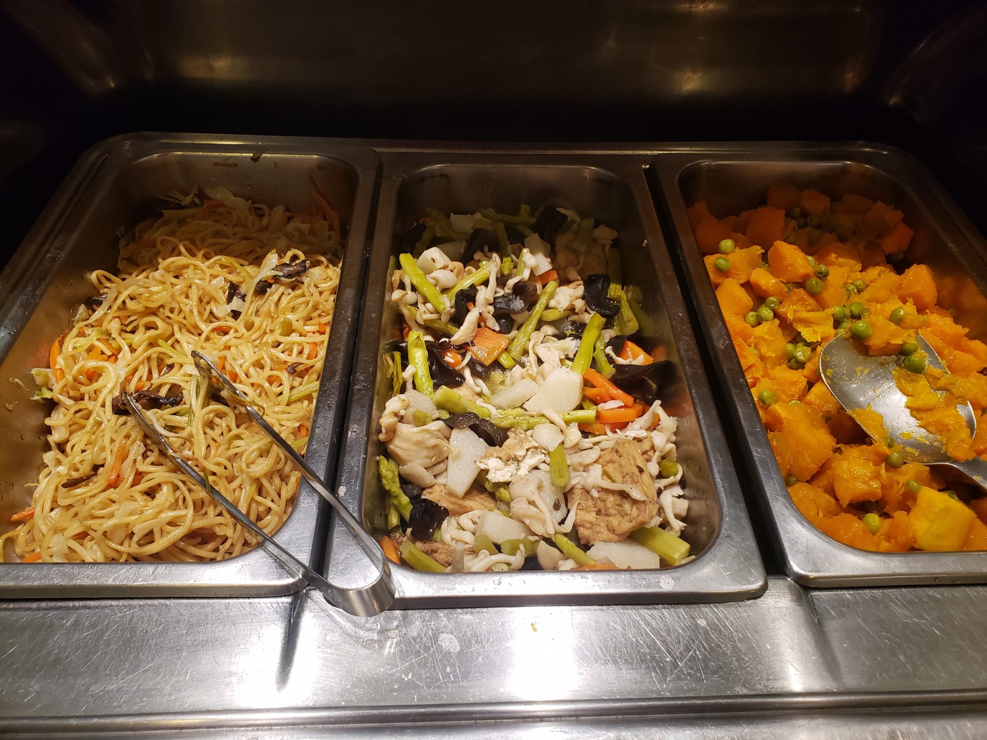 a row of food containers with noodles and vegetables