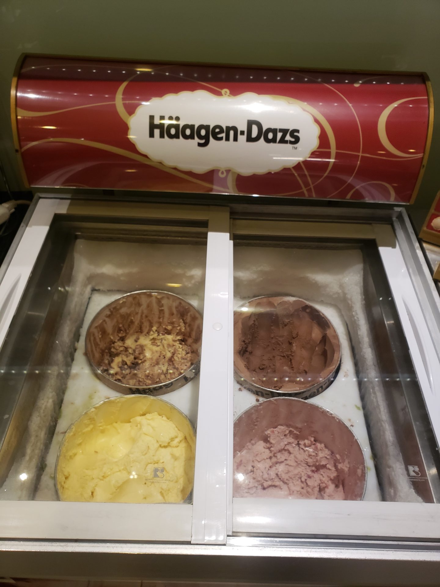 a freezer with different flavors of ice cream