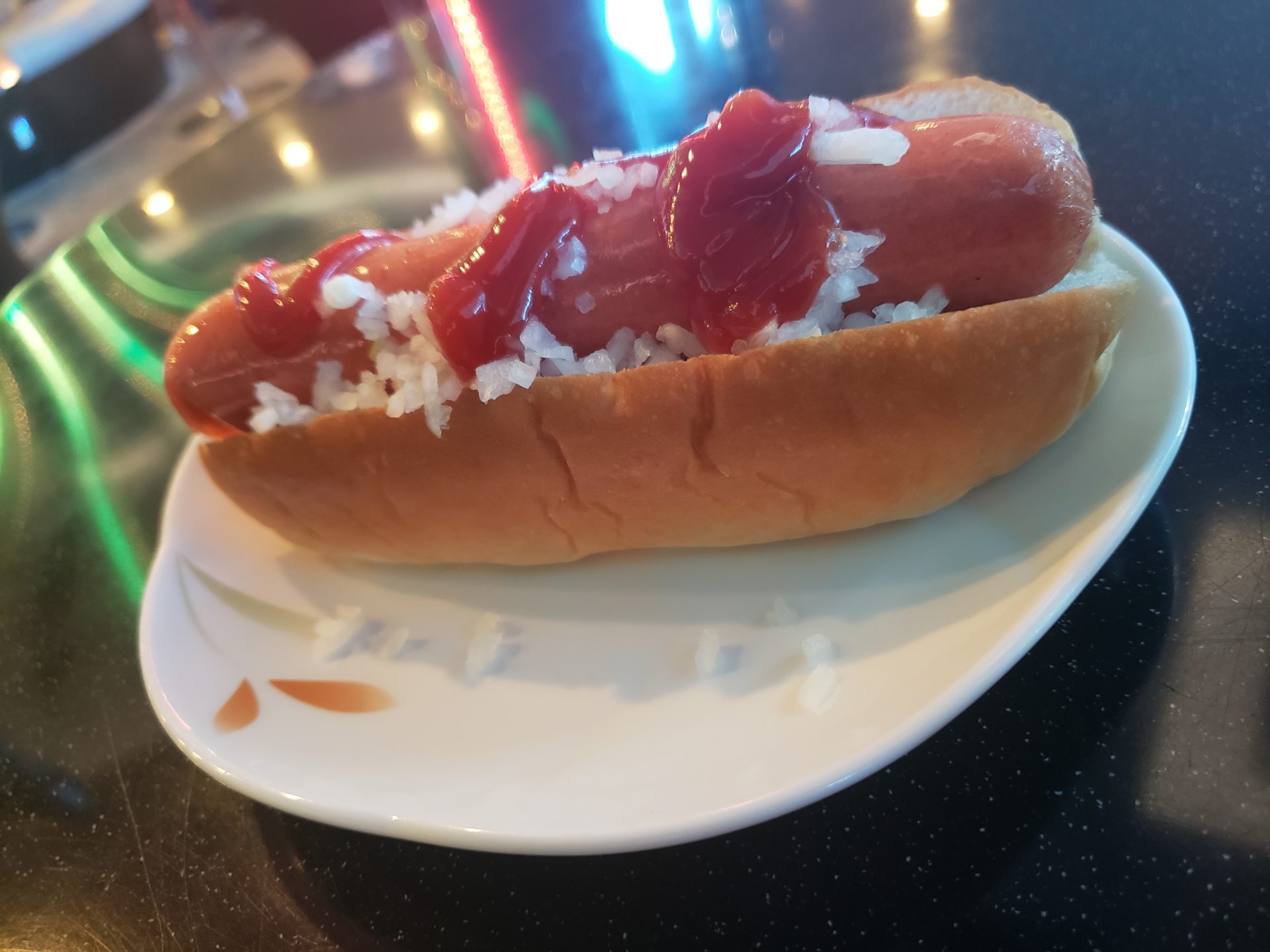 a hot dog with rice and ketchup on a plate