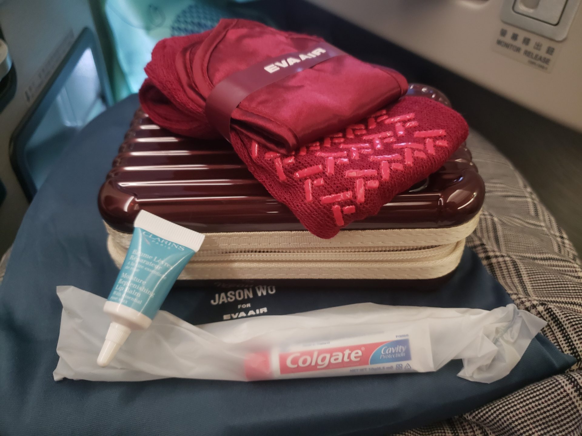 a suitcase with a red towel and a tube of toothpaste on a blue surface