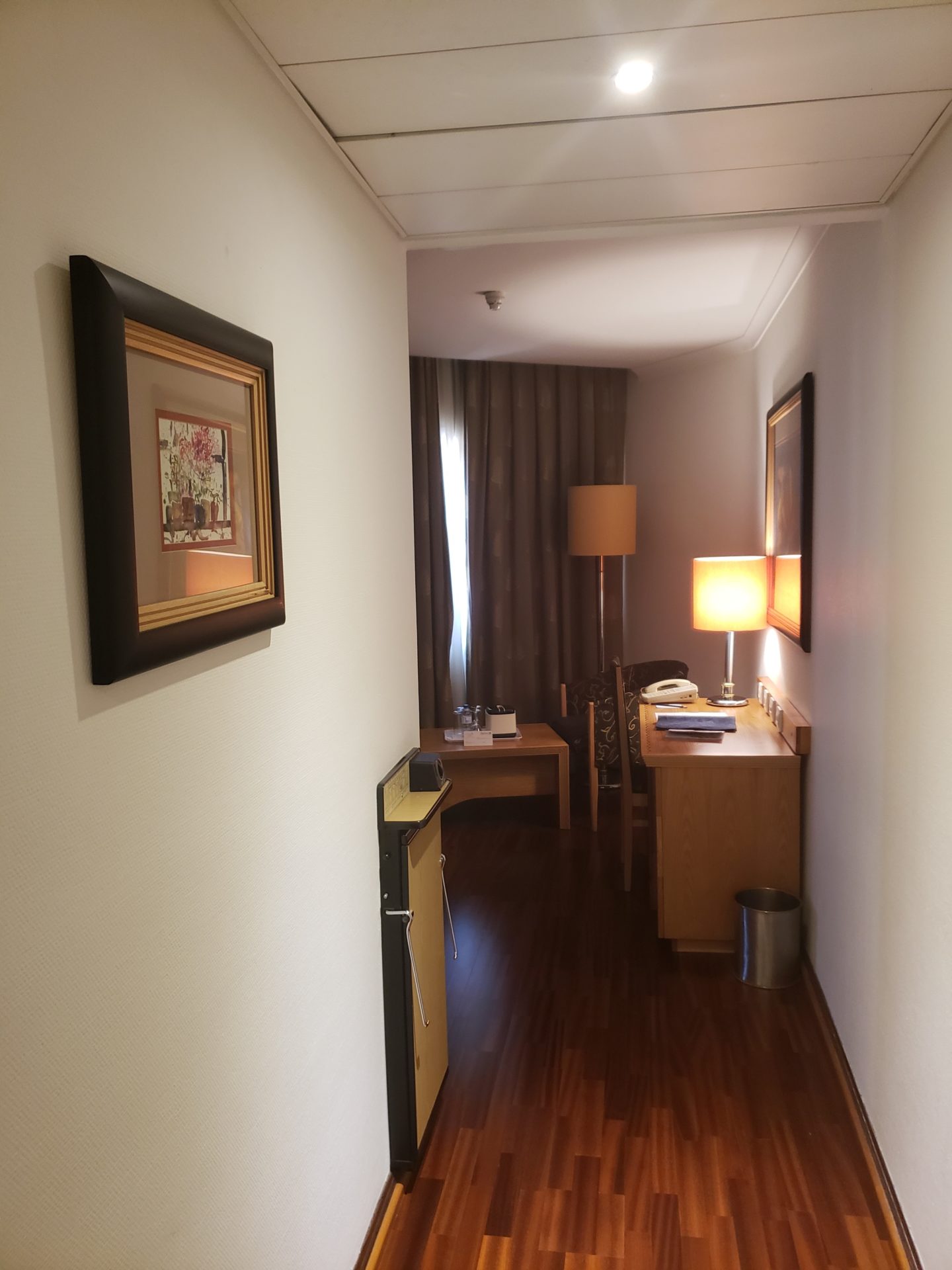 a room with a desk lamp and a picture on the wall