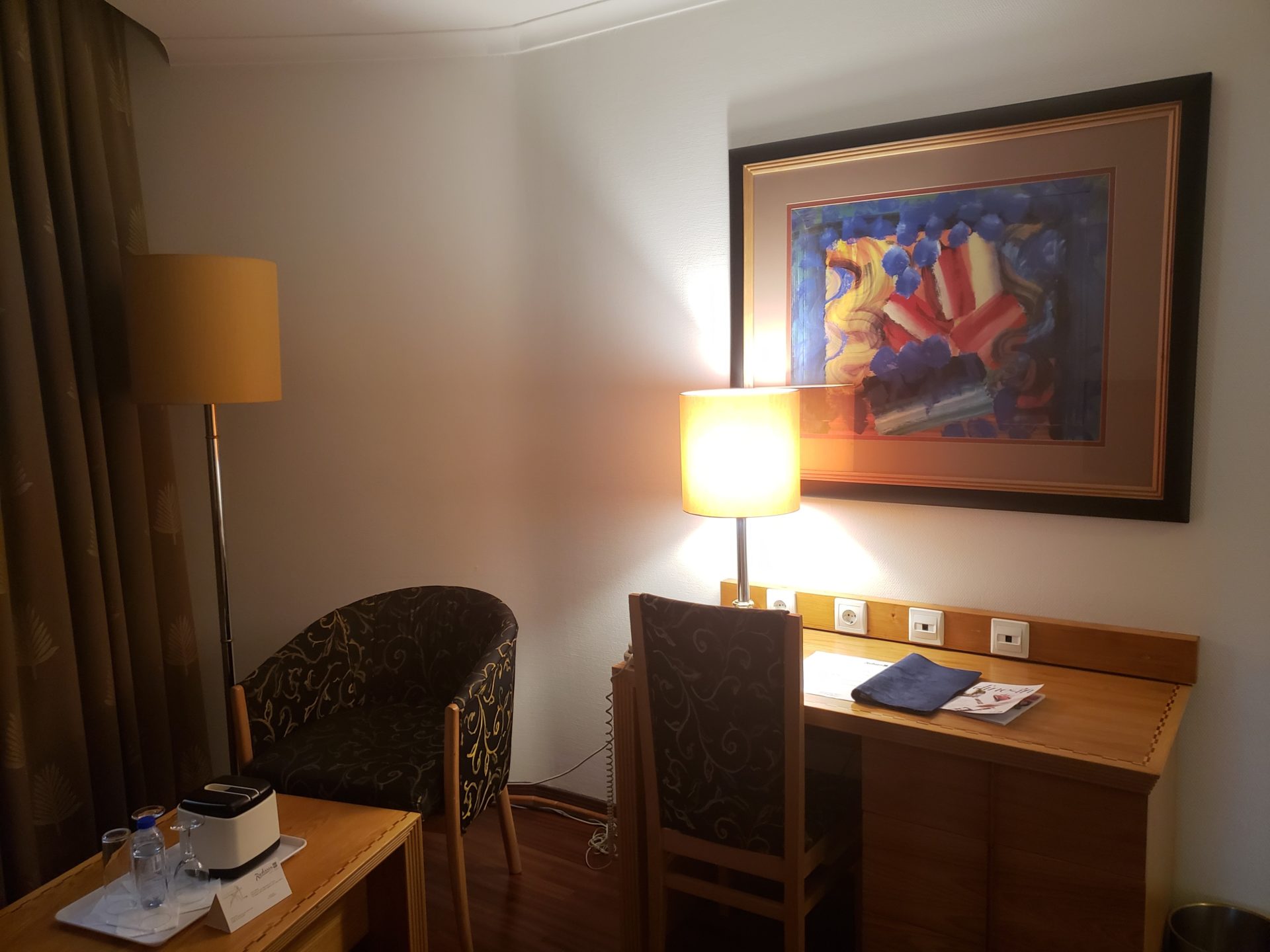 a room with a painting and a desk
