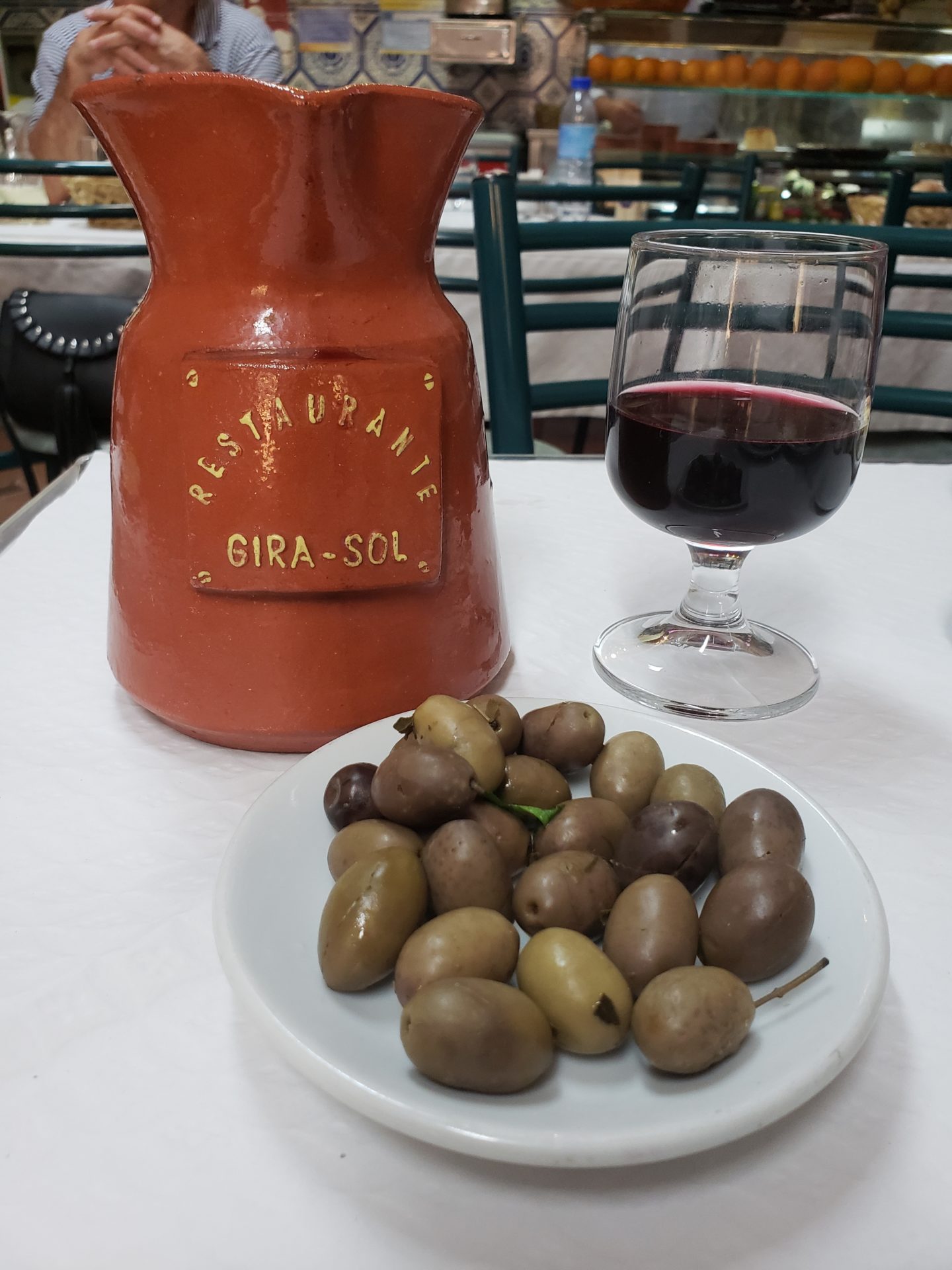 a plate of olives and a glass of wine