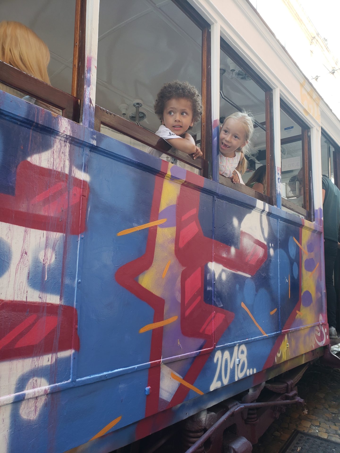 a group of kids looking out of a window of a trolley