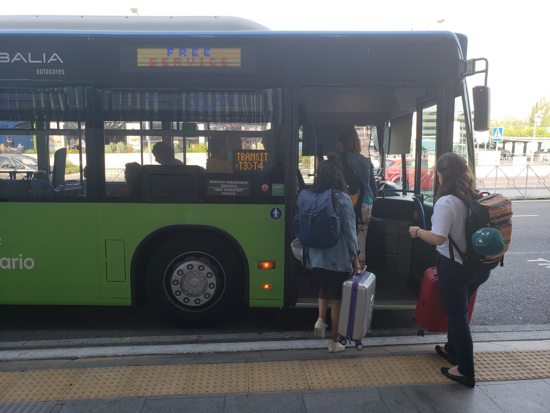people standing next to a bus
