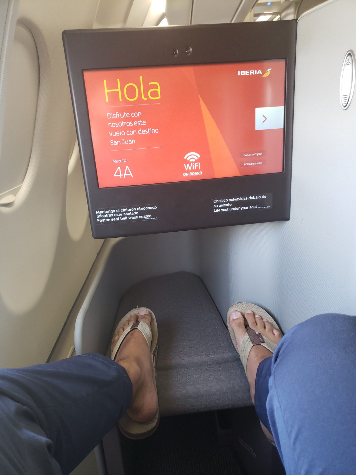 a person's feet in sandals on a seat in an airplane