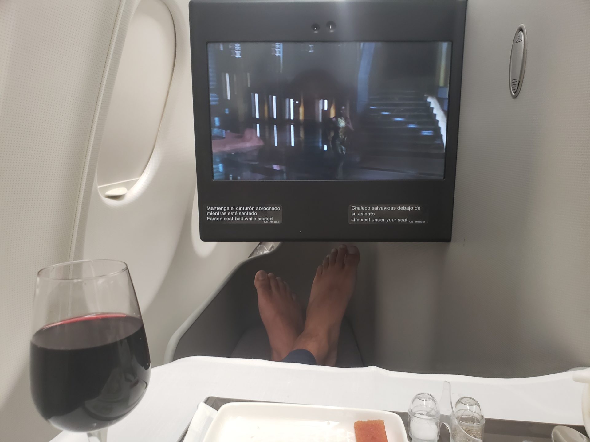 a person's feet in a tv on an airplane