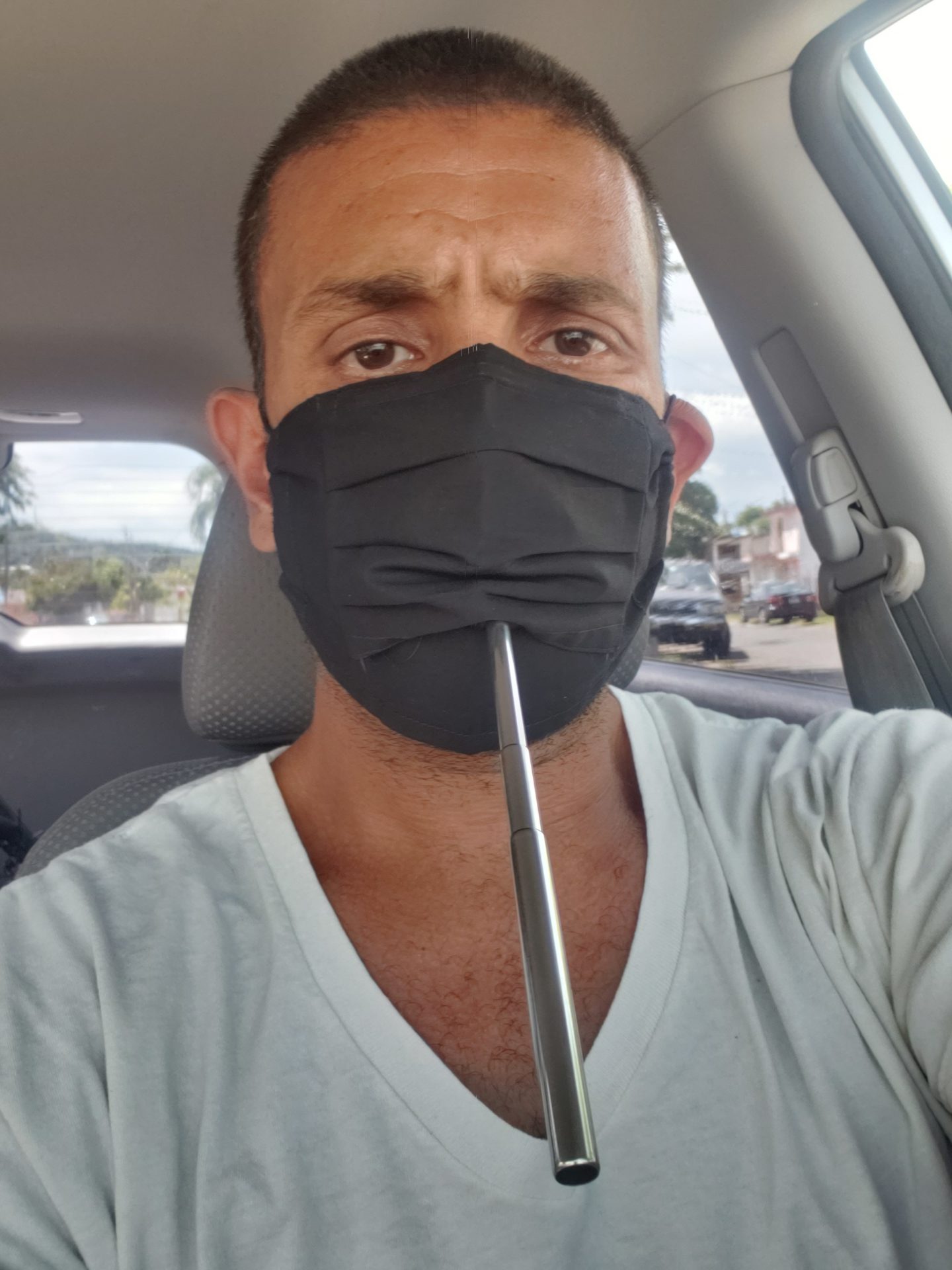 a man wearing a black face mask and smoking pipe