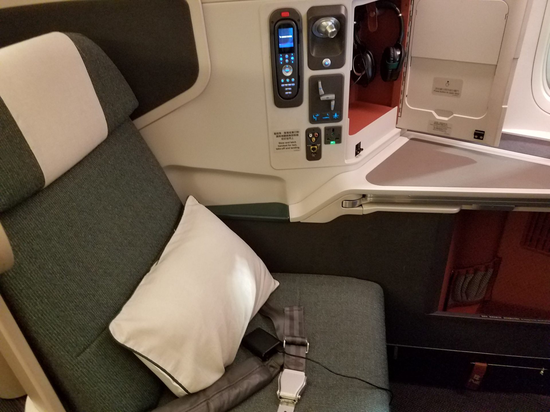 a seat with a seat belt and a pillow on the side of the seat